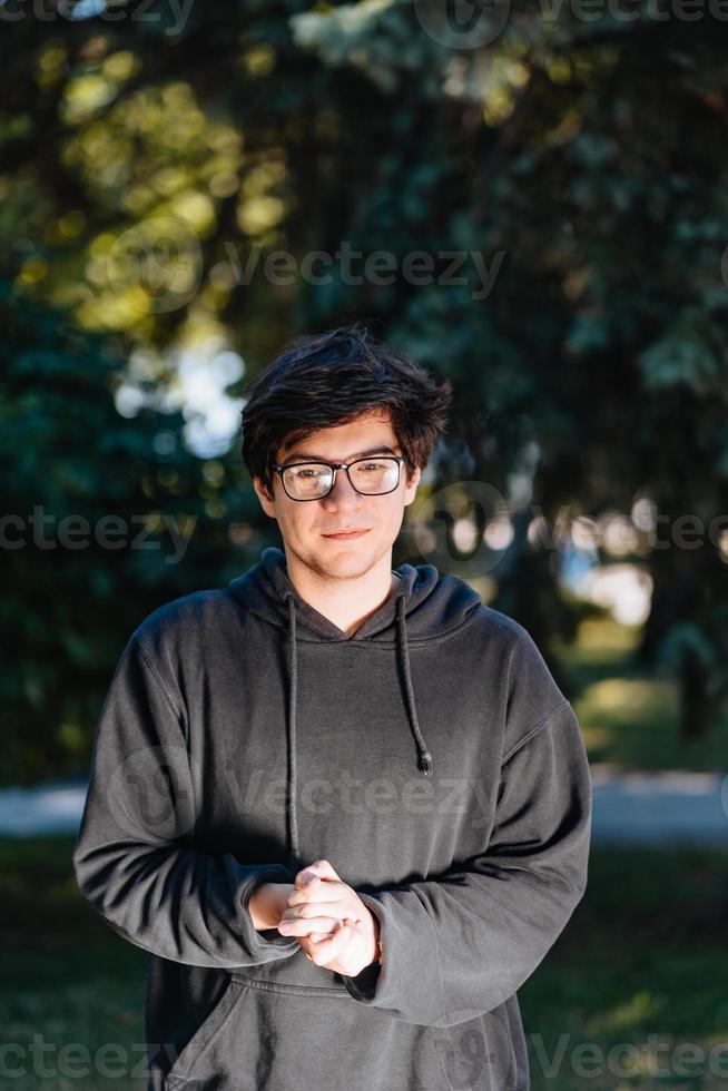 Portrait of happy young male student with glasses in casual outfit photo