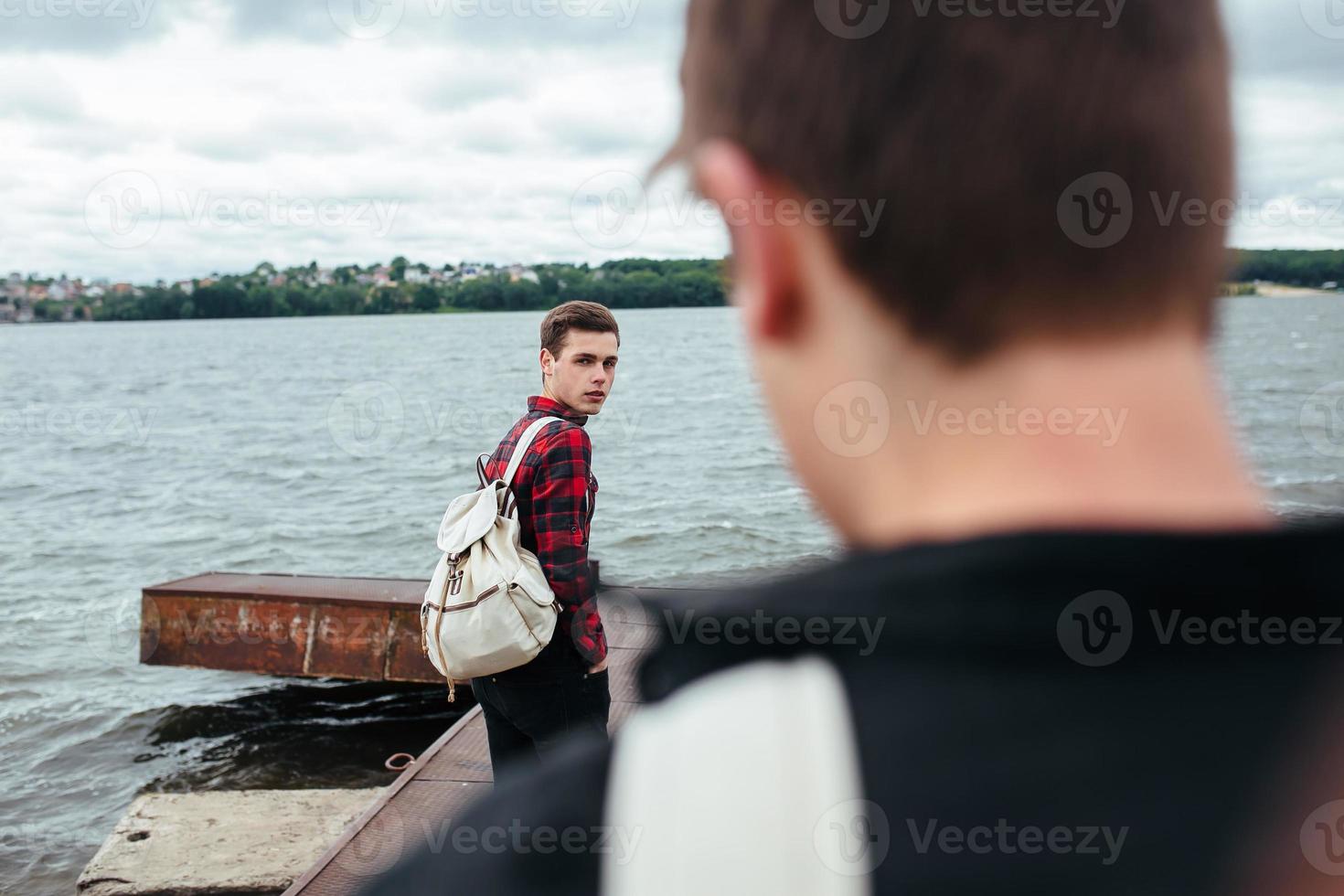 two young guys standing on a pier photo