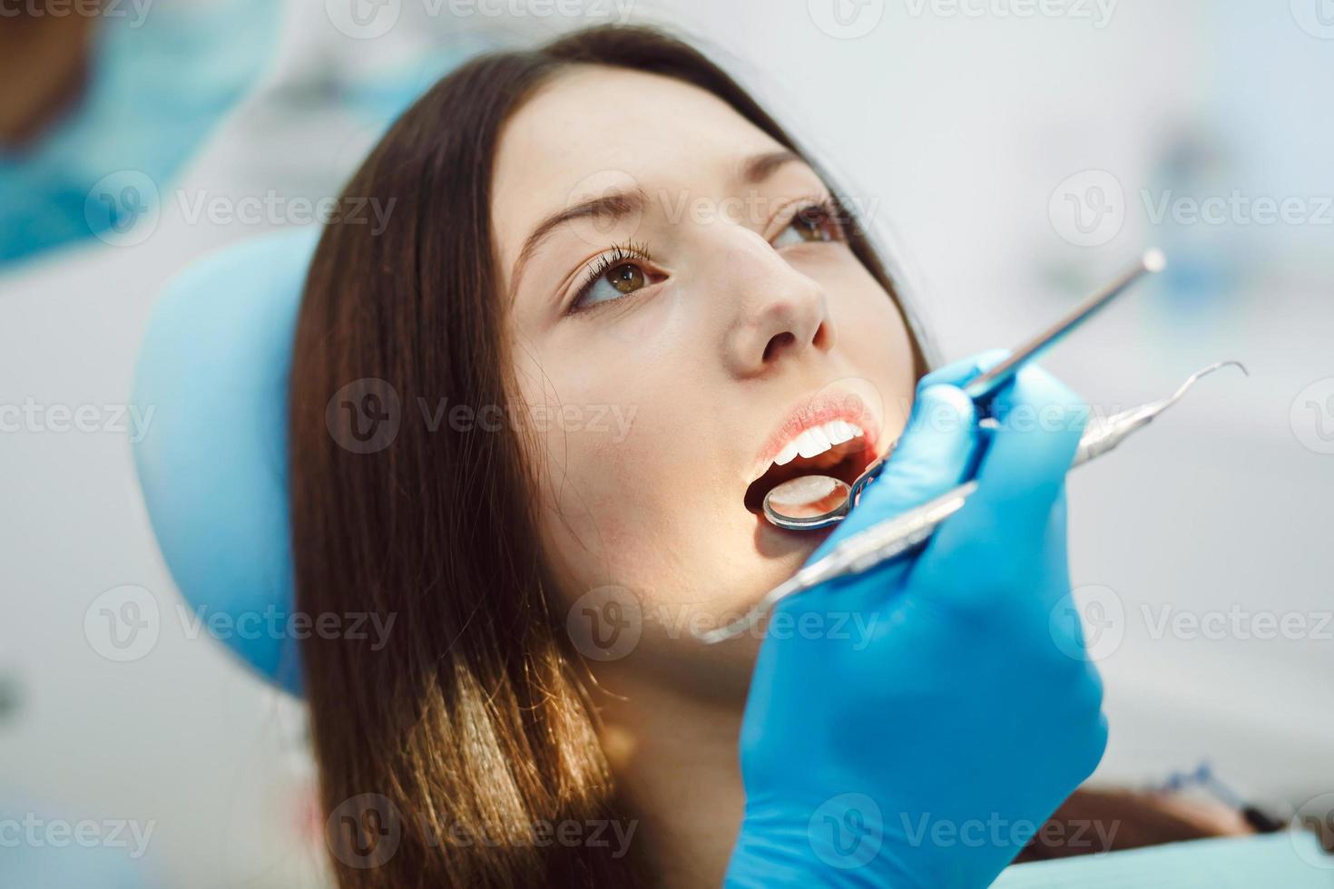 inspección de los dientes de la niña con la ayuda de un espejo foto