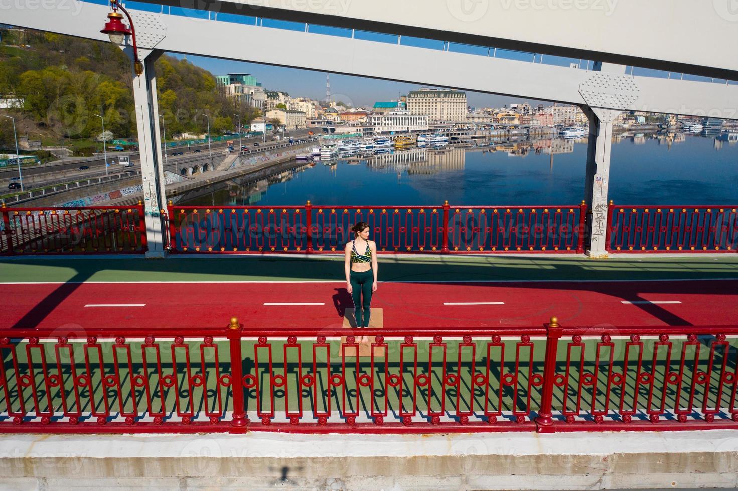 Beautiful Energetic Fitness Girl Doing Exercises on Bridge. photo