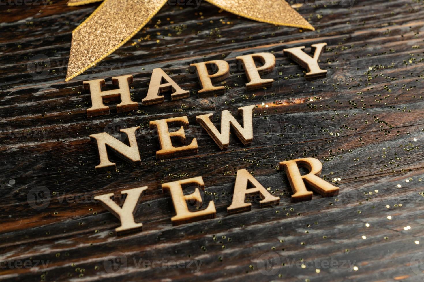 Happy new year wooden text on wooden background. Festive greeting card. photo