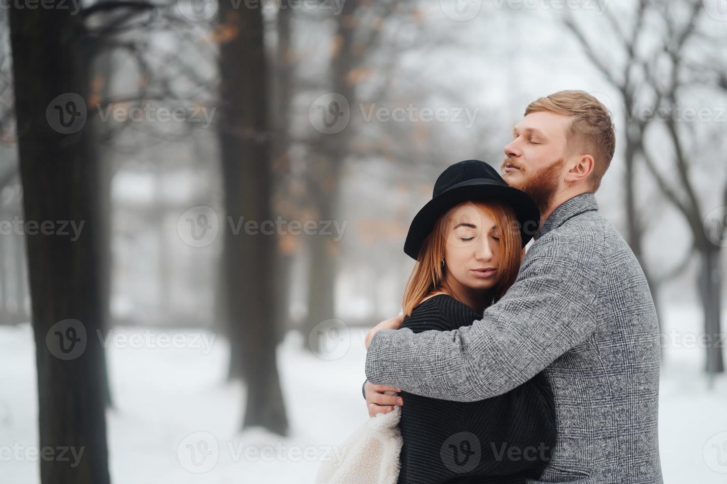 The guy and the girl are resting in the winter forest. photo