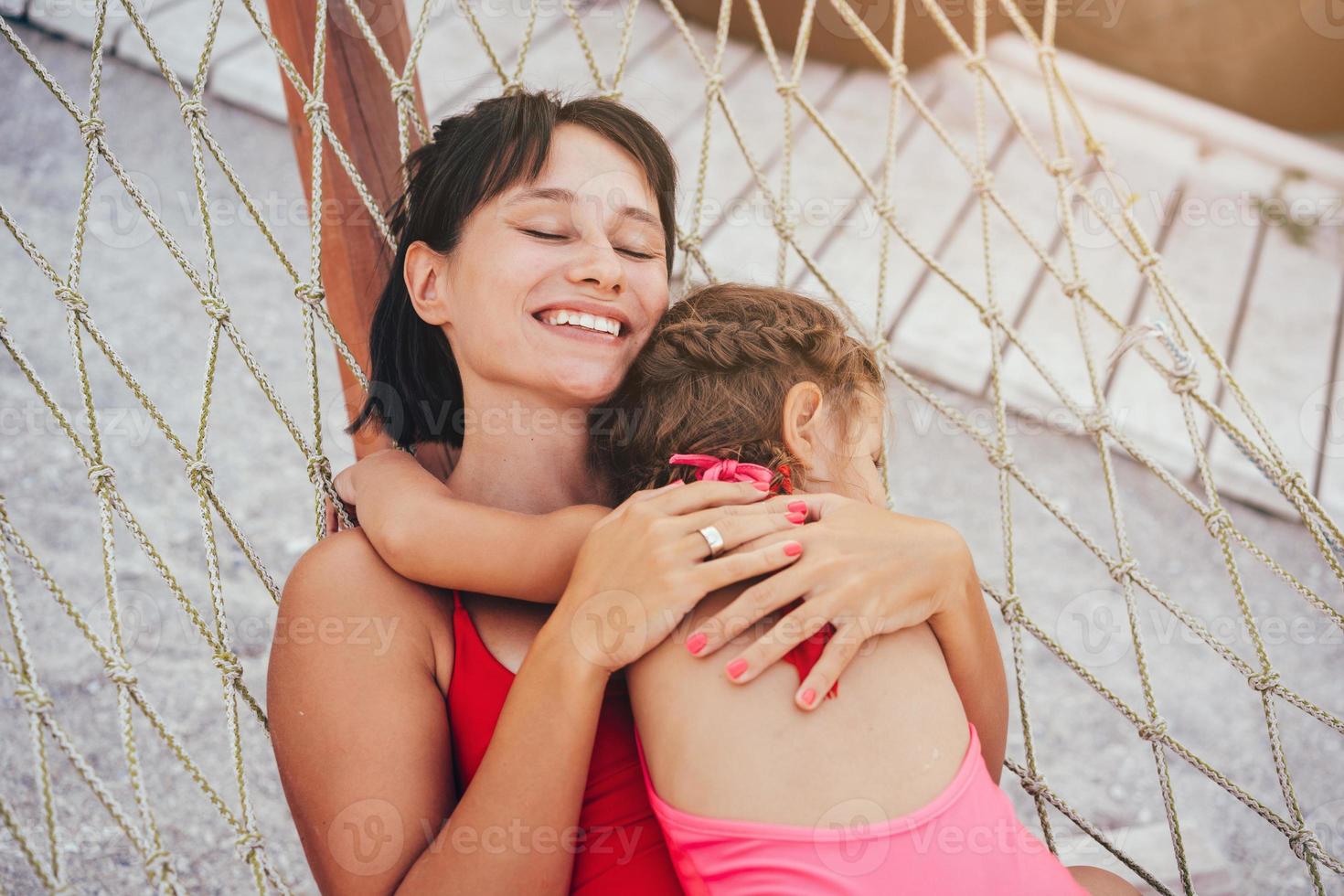 happy mother with her daughter lying in a hammock photo