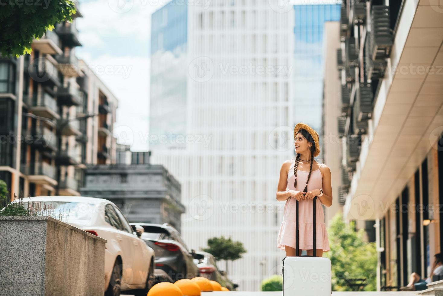 Young woman with suitcase and looks to the side photo