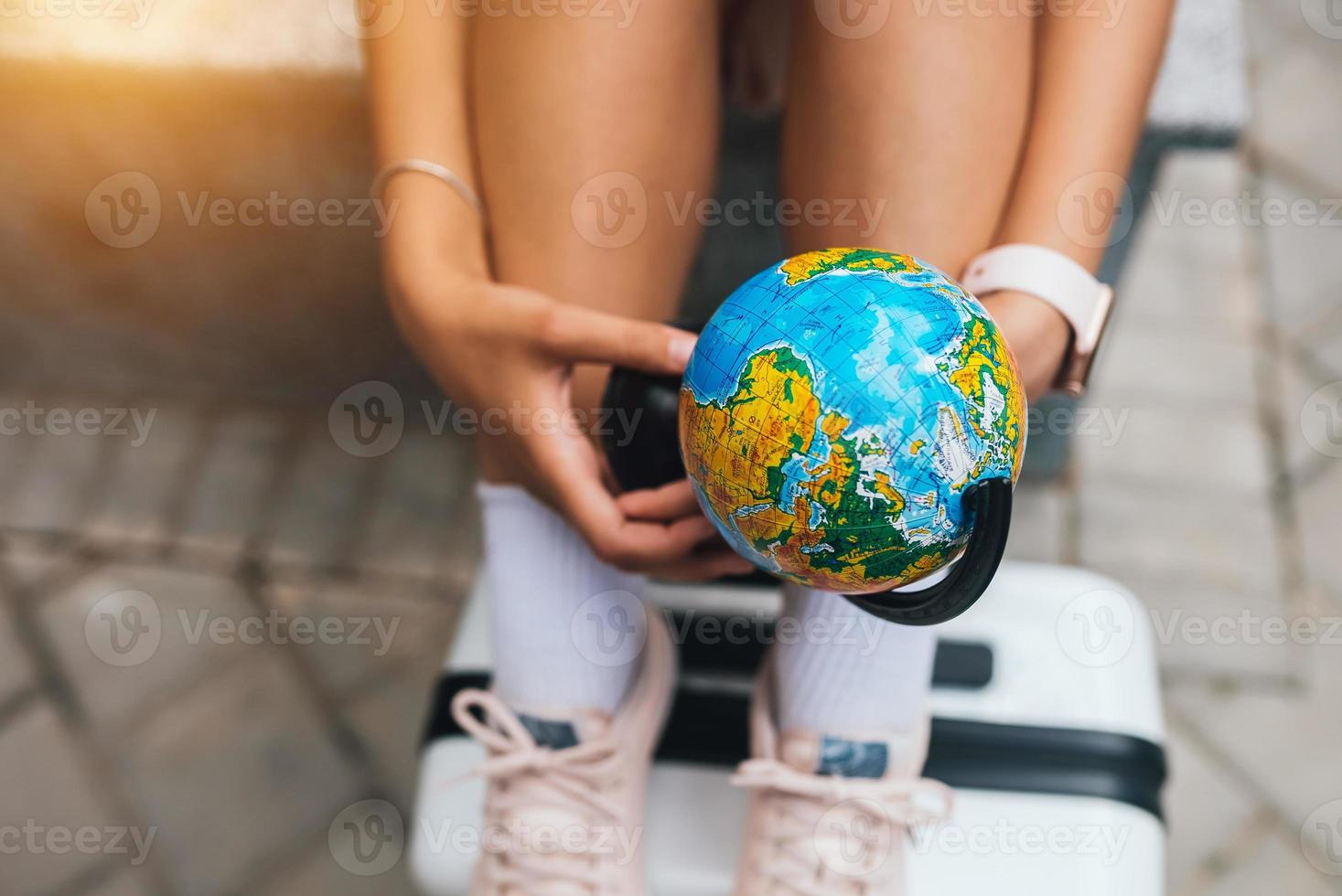 foto recortada bella joven sostiene un pequeño globo terráqueo