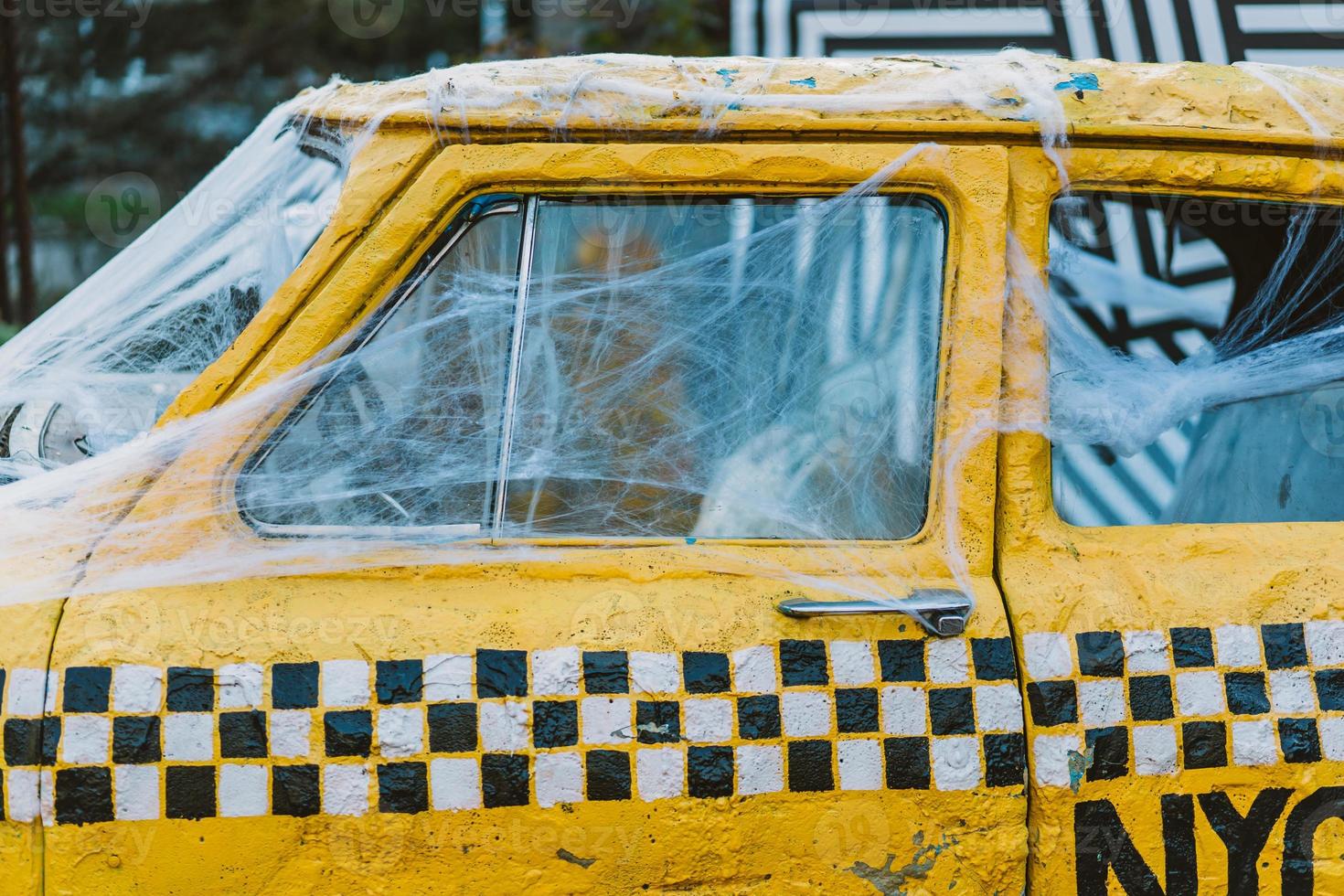 Old retro yellow taxi decorated with cobwebs photo