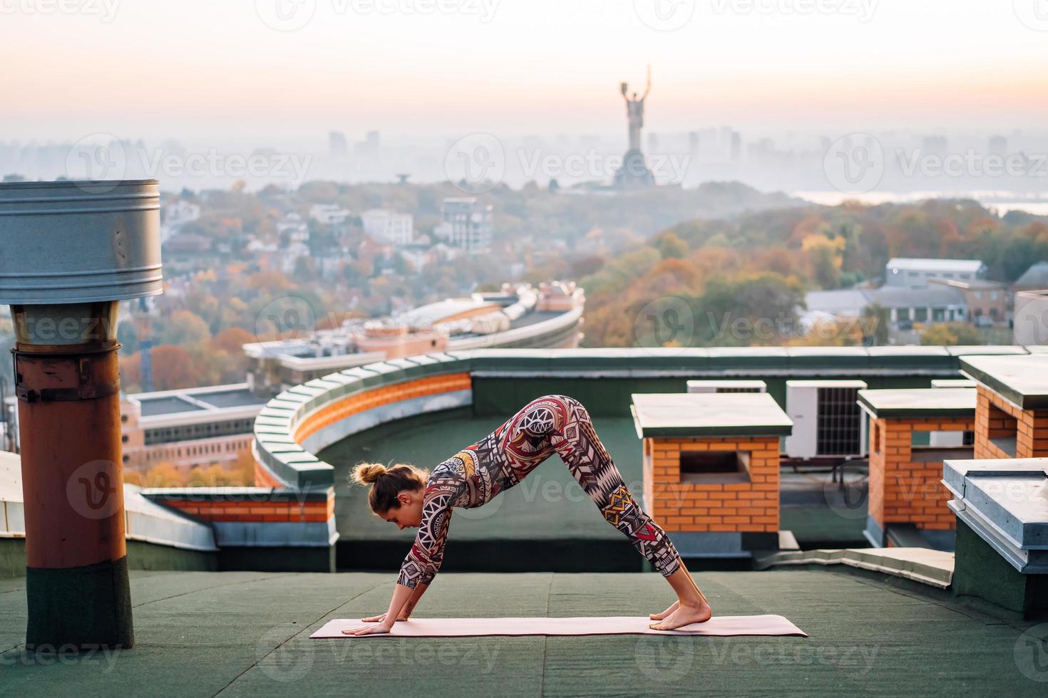 mujer haciendo yoga en la azotea de un rascacielos en la gran ciudad. foto