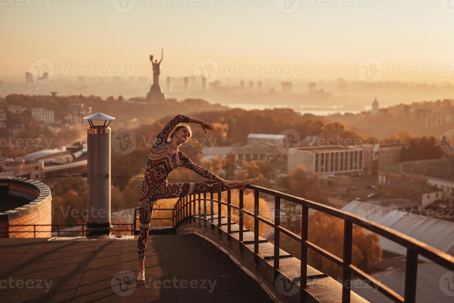 mujer haciendo yoga en la azotea de un rascacielos en la gran ciudad. foto