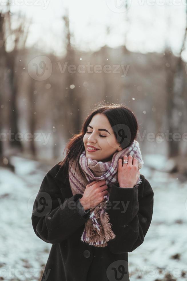 Young beautiful model posing in winter forest. stylish fashion portrait photo