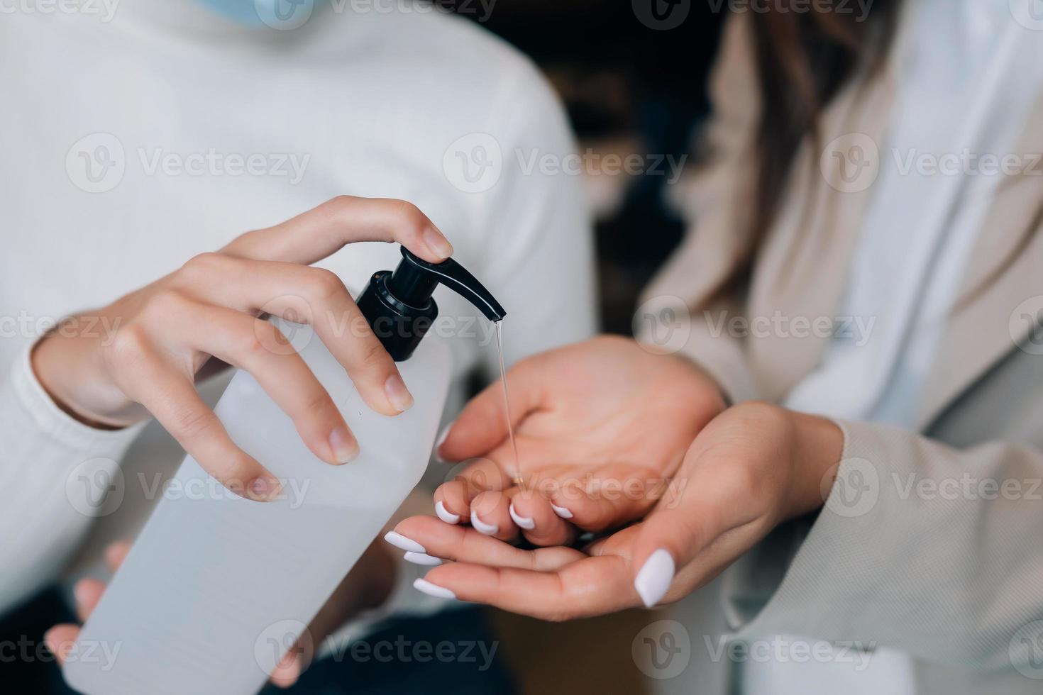 Female hands applying antibacterial liquid soap close up. photo