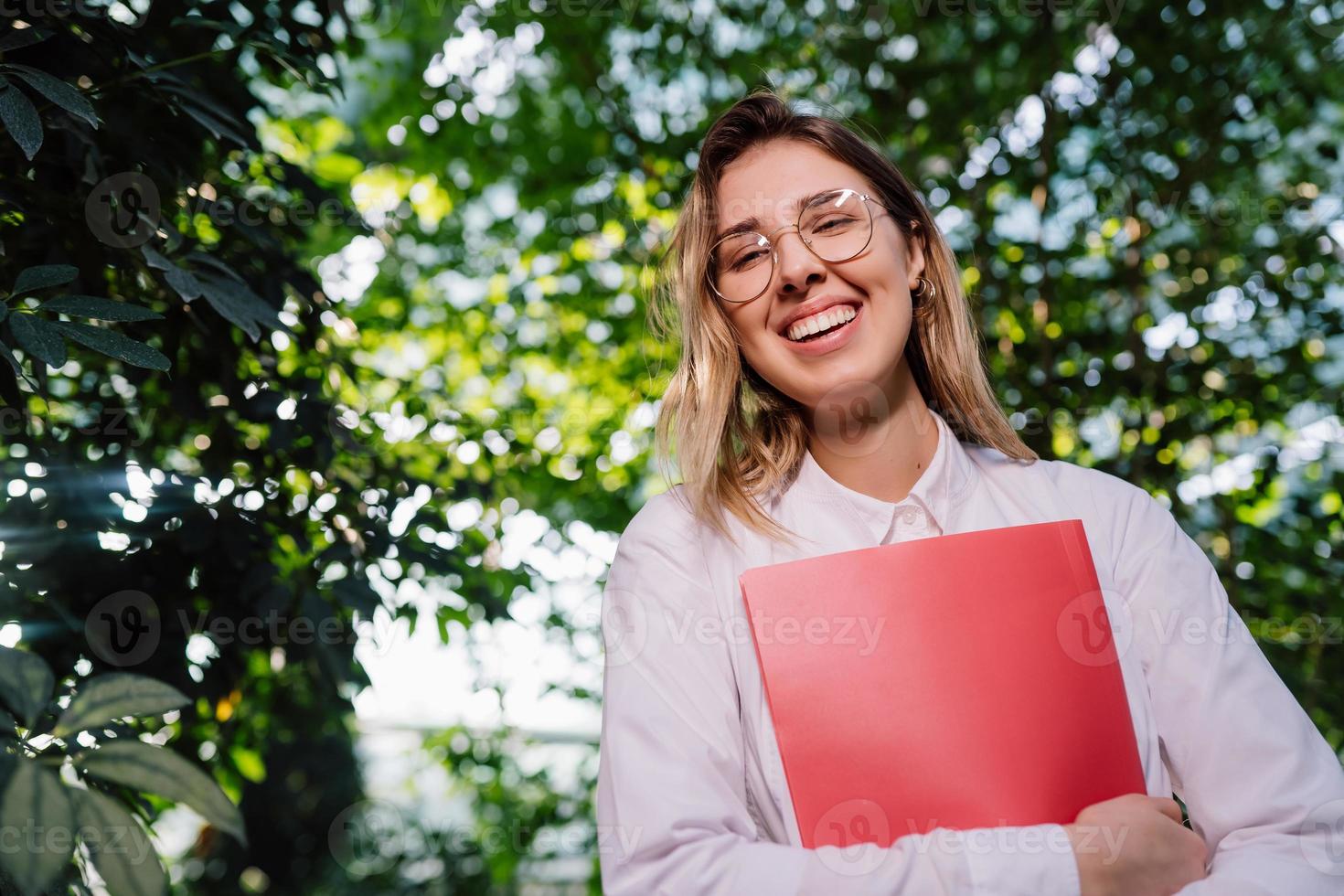 Young female agricultural engineer working in greenhouse. photo