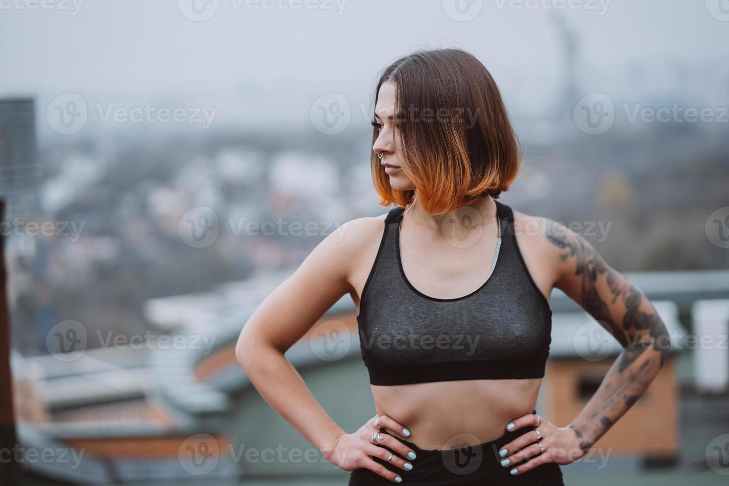 Girl poses on the roof of a building in the city center photo