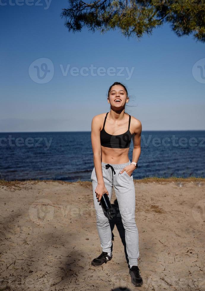 mujer joven fitness camina en el parque y posa para la cámara foto