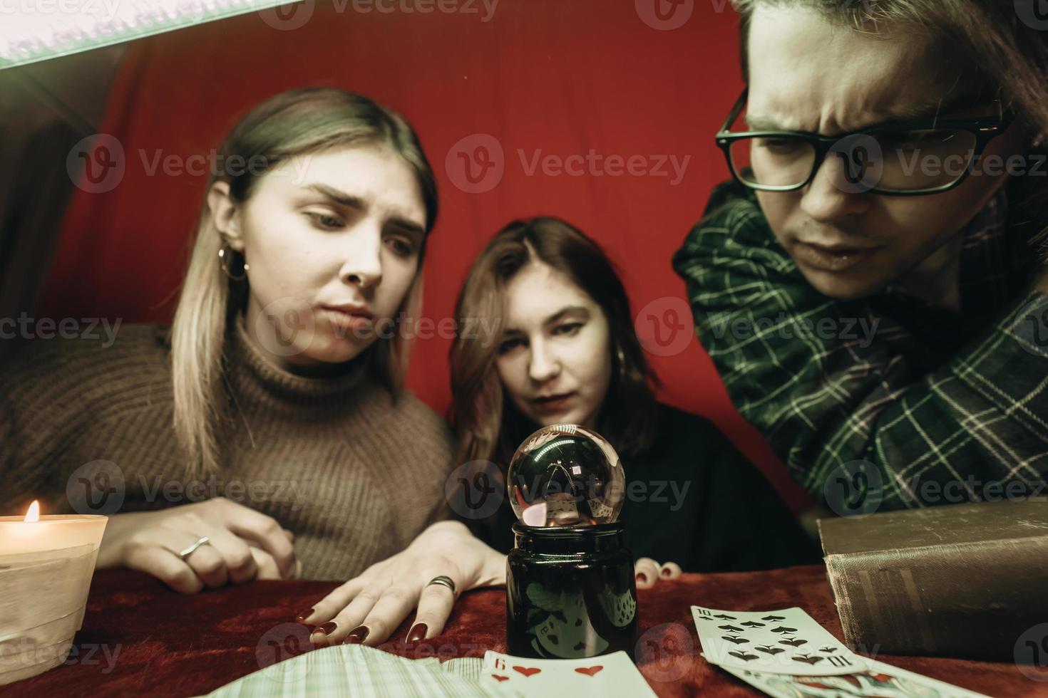 grupo de personas y mujer adivina con bola de cristal foto