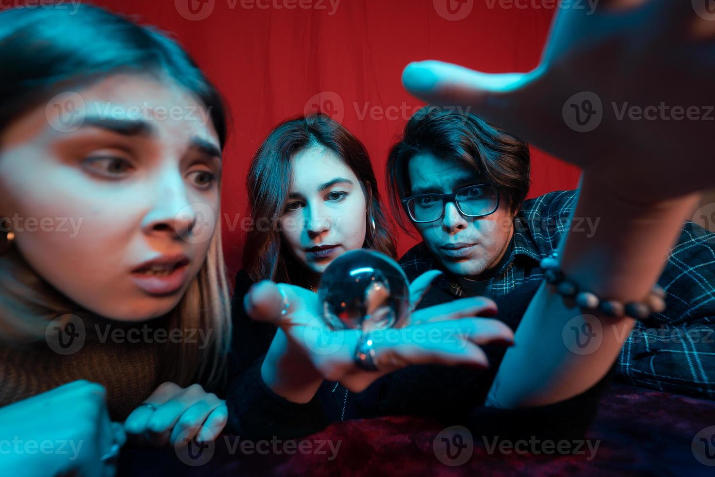 grupo de personas y mujer adivina con bola de cristal foto