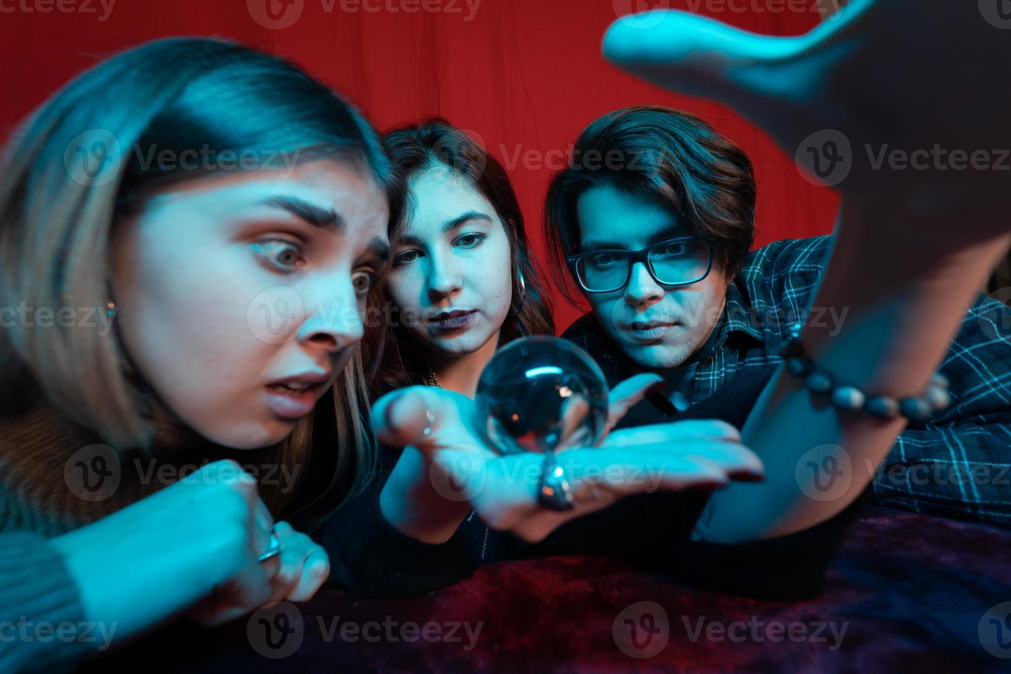 Group of people and woman fortune teller with crystal ball photo