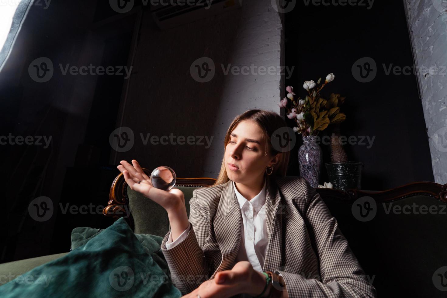 Woman in business suit holding crystal ball photo