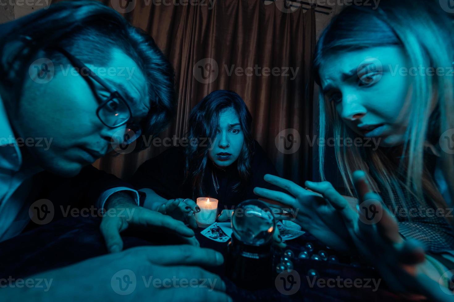 Group of people and woman fortune teller with crystal ball photo