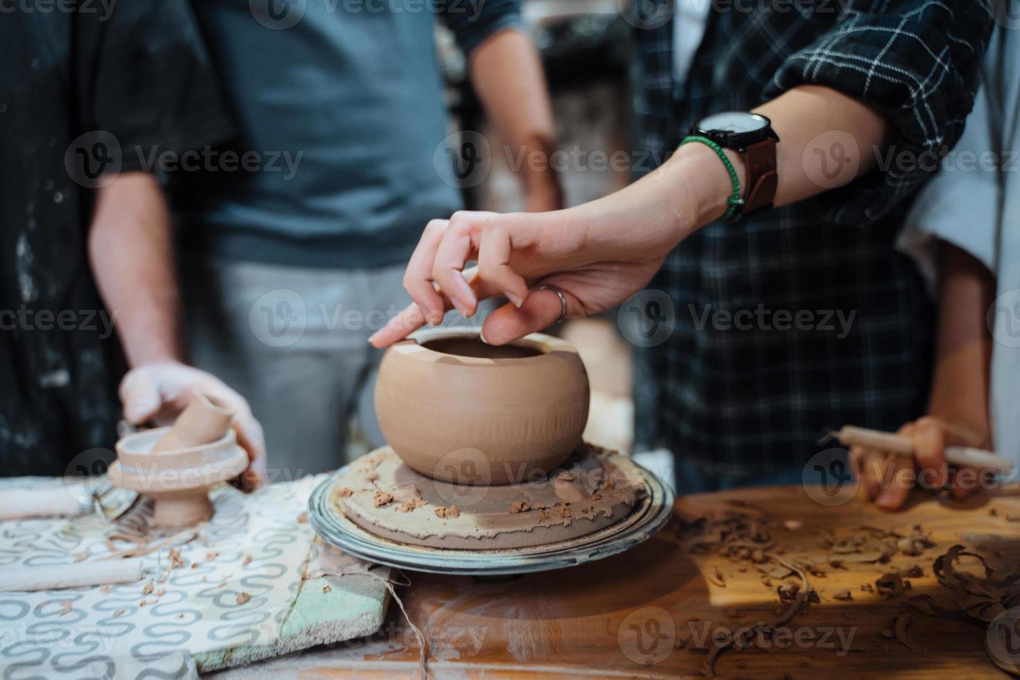 haciendo una olla de barro hecha a mano en el taller. lección de cerámica con el maestro. foto