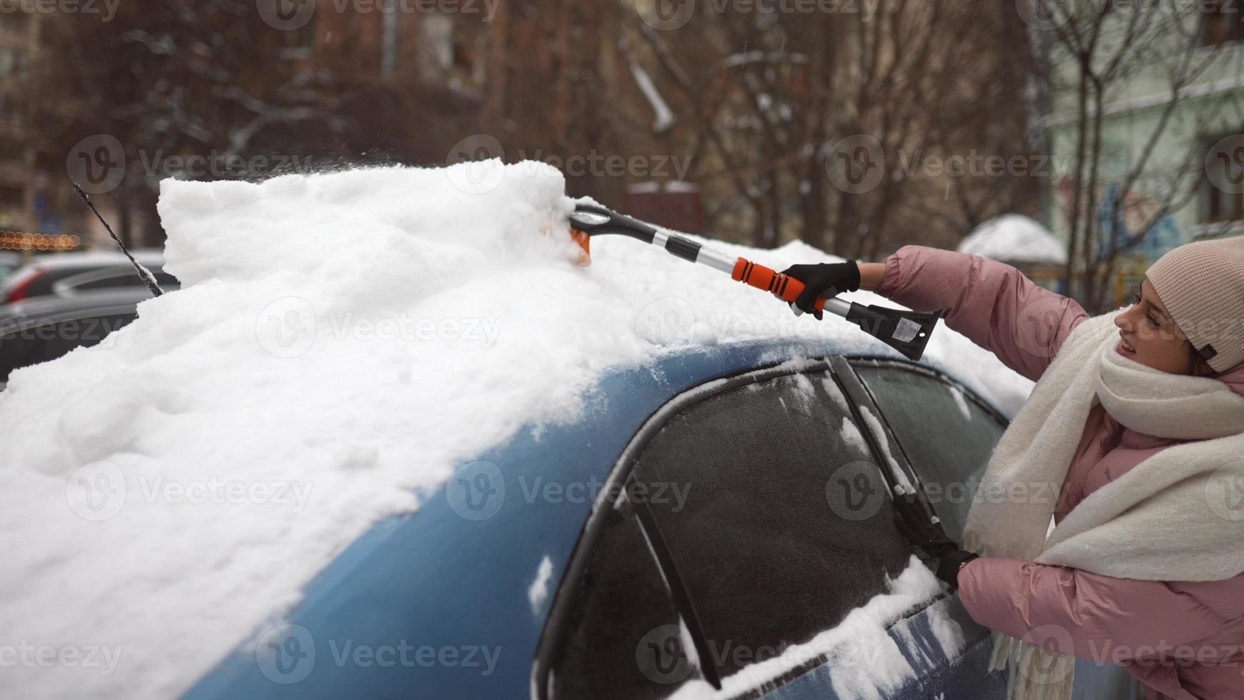 Woman removing snow from car photo
