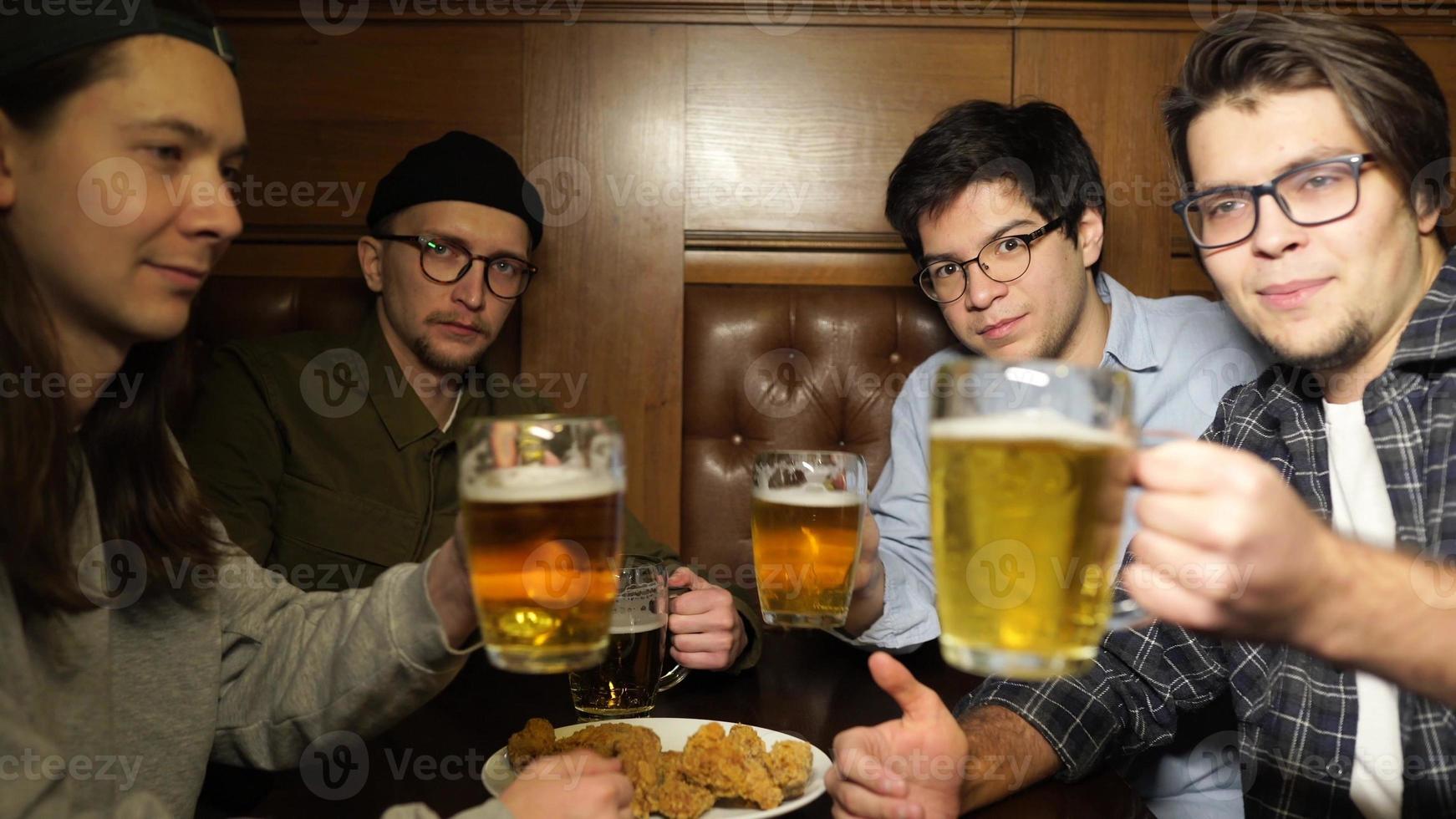 Young friends having fun together drinking beer in a pub. photo