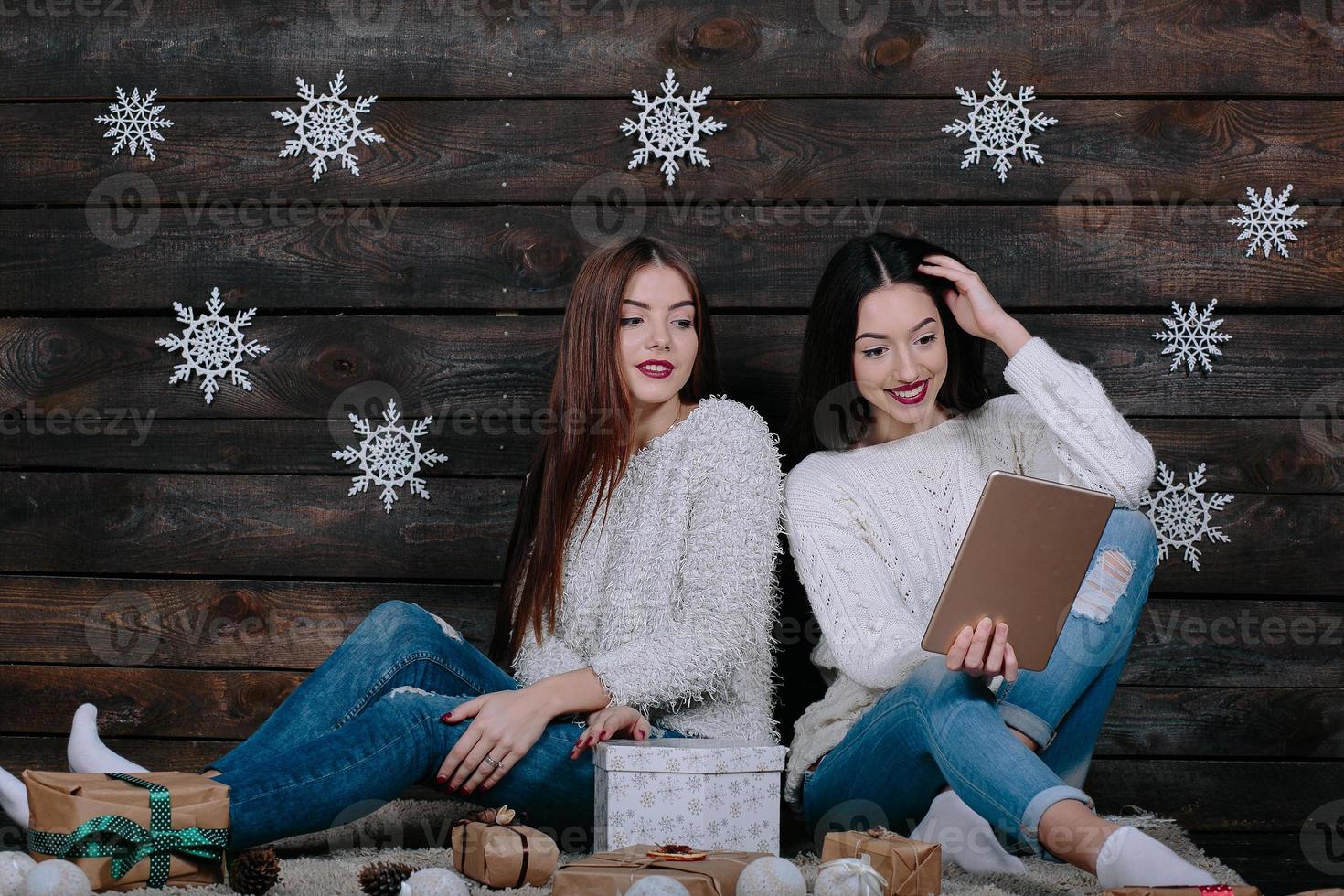 Two beautiful girls with a tablet, between gifts photo