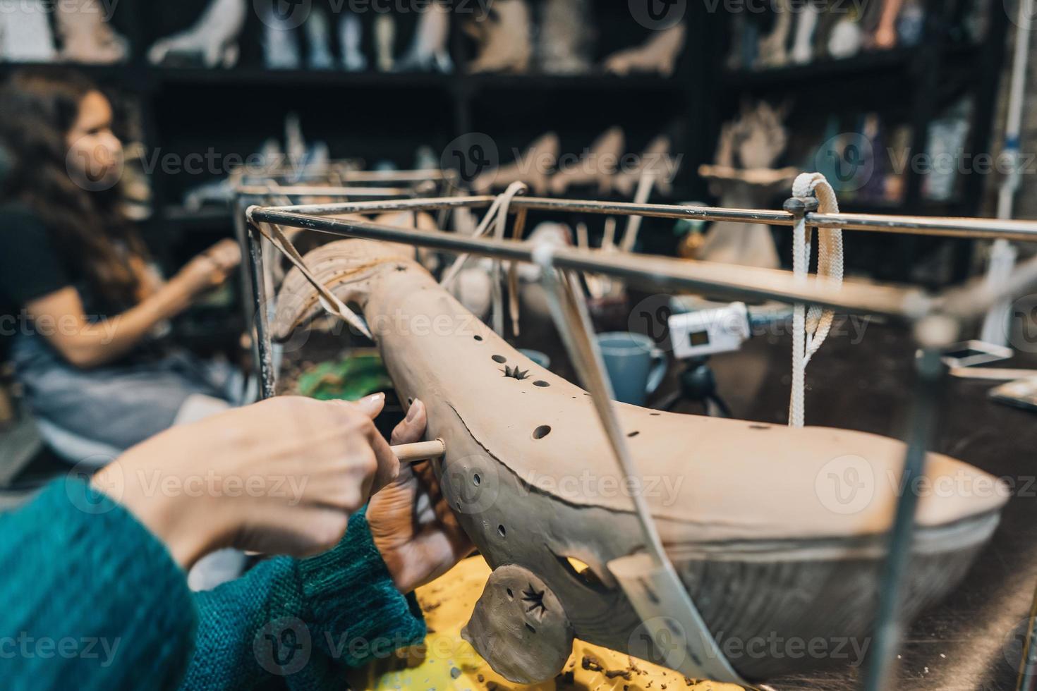 People carefully work on clay whales in workshop photo