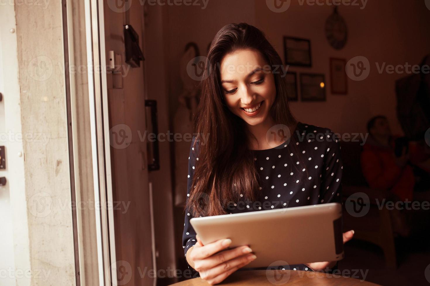 Beautiful girl working on a tablet and smiling.  Instagram toning effect photo