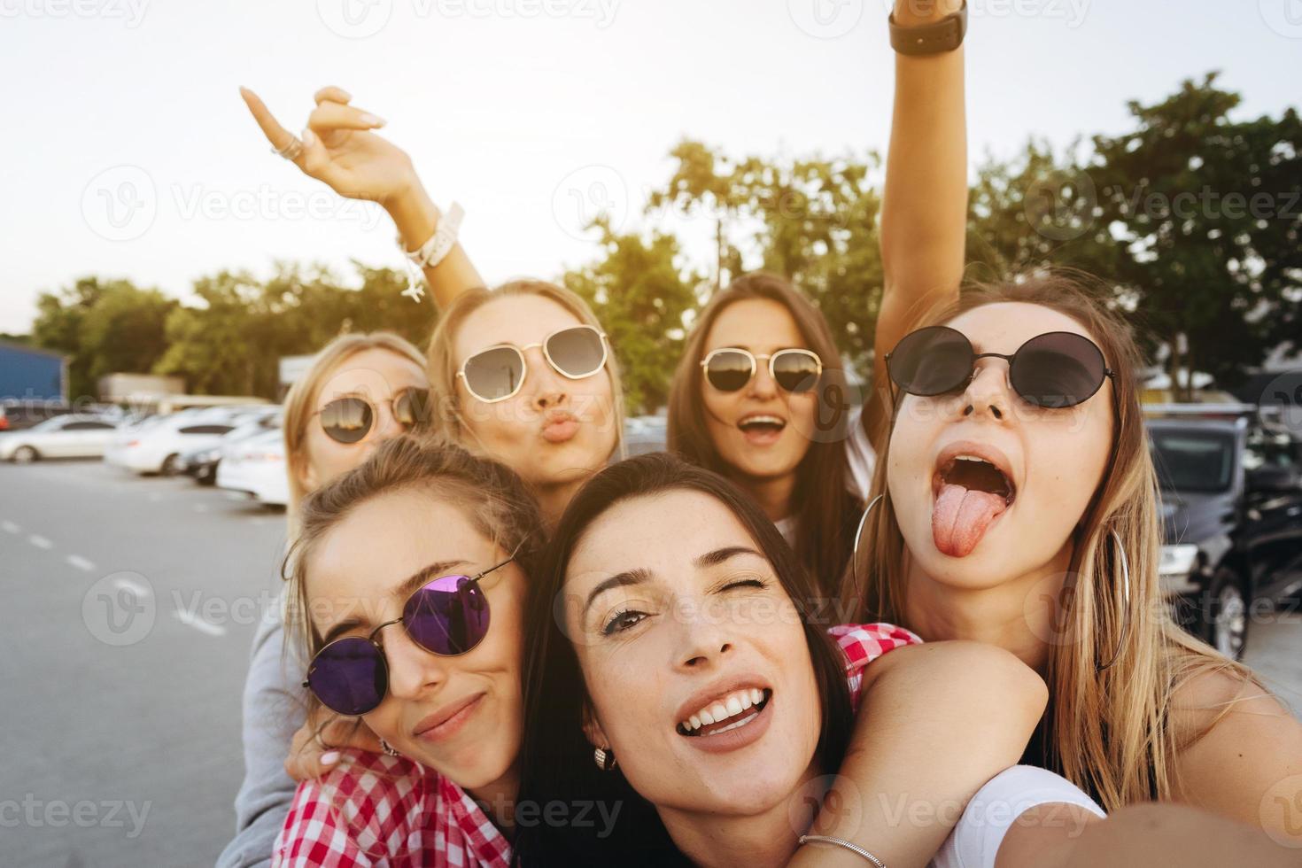 Six young beautiful girls looking at the camera and taking a selfie photo