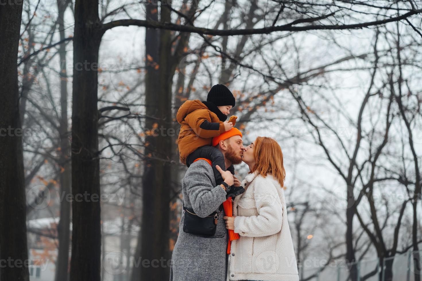 Dad mom and baby in the park in winter photo