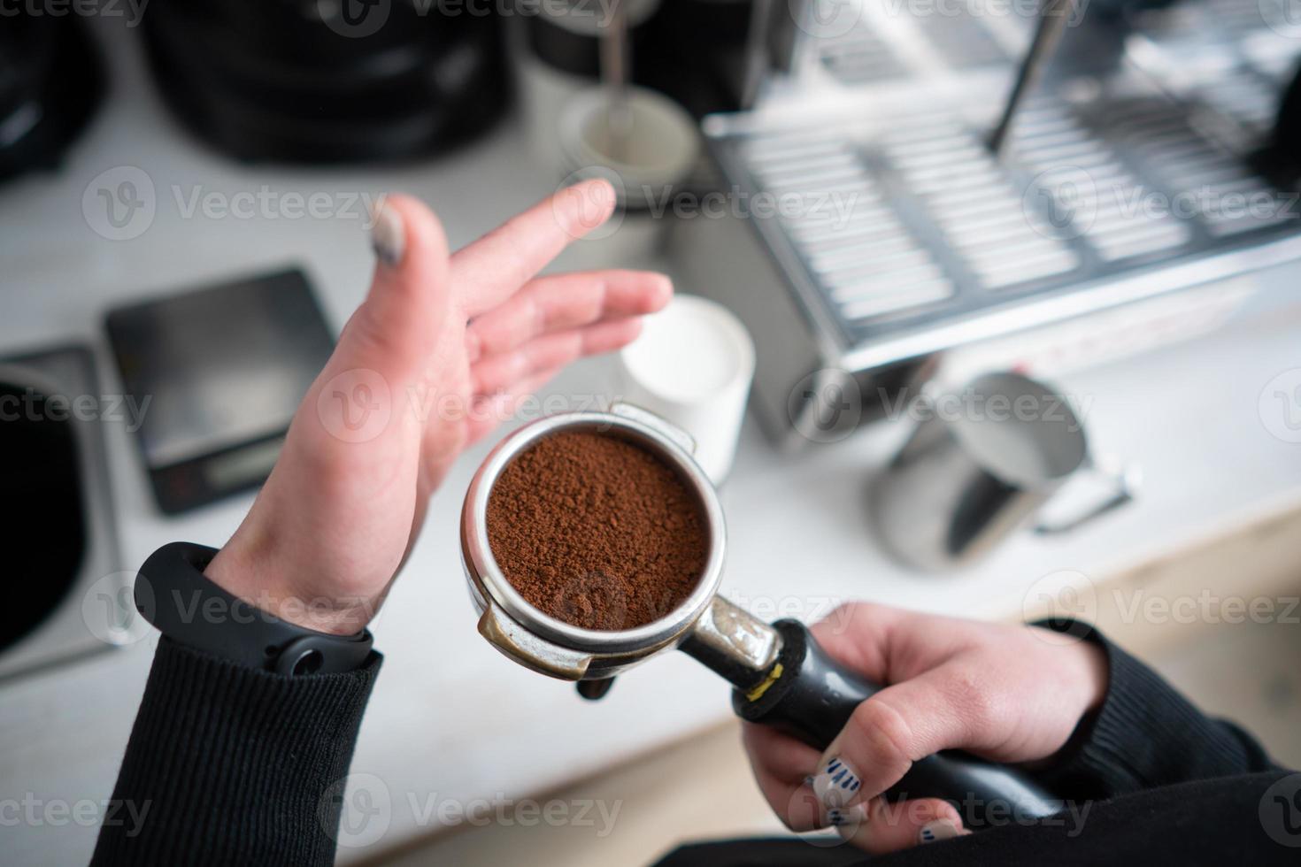 Barista holding portafilter with ground coffee photo