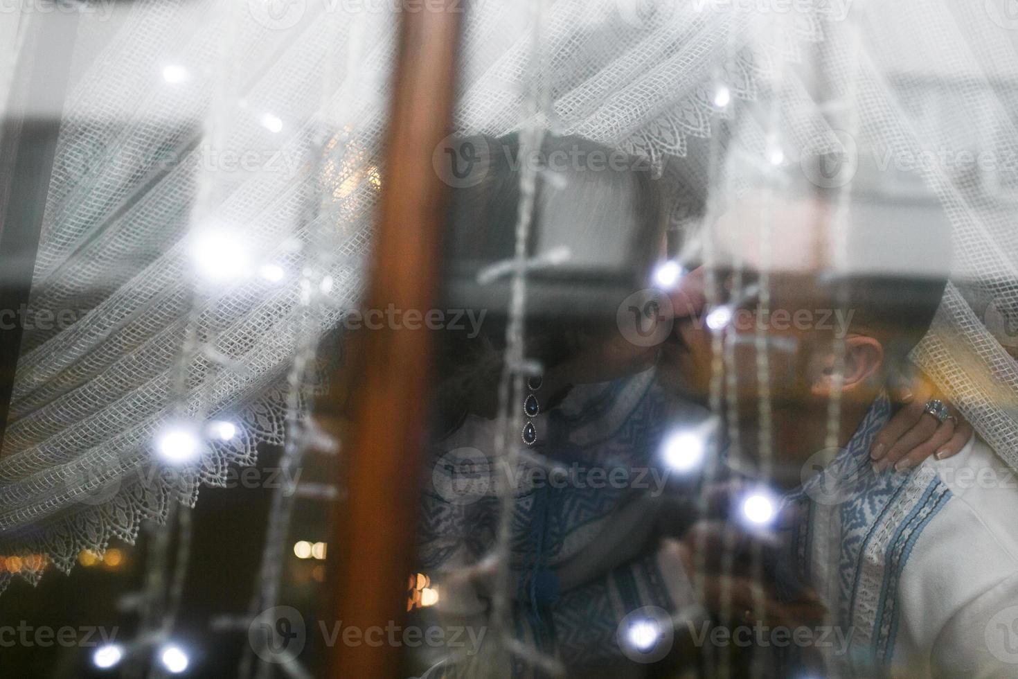 hermosa pareja en la ventana con guirnaldas fuera de foco foto