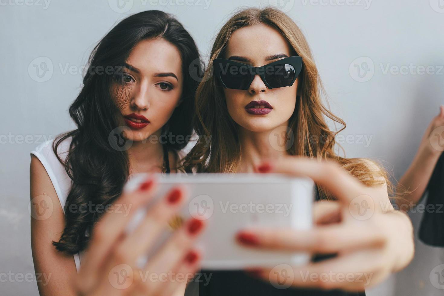 Two girlfriends taking a selfie photo