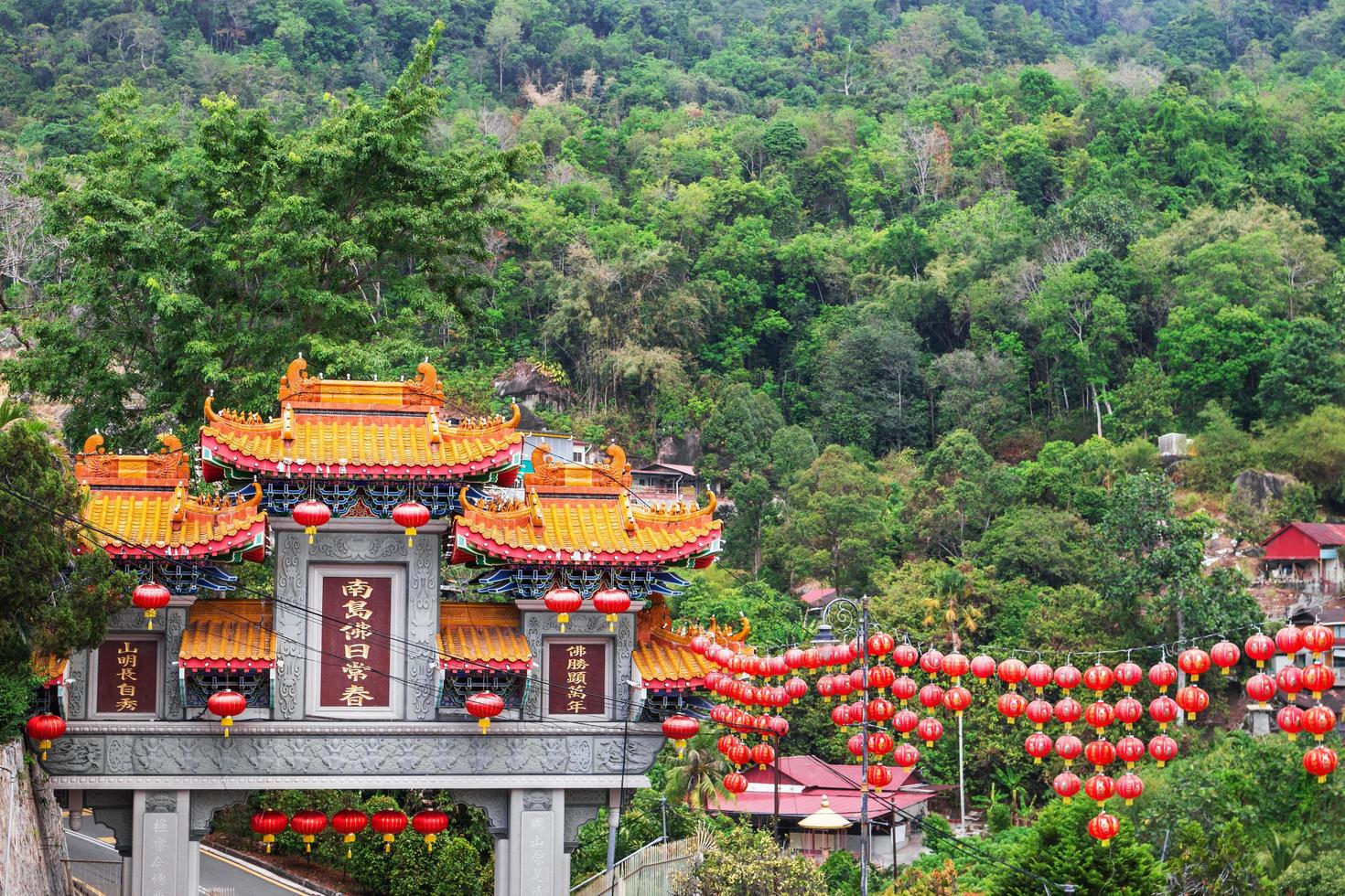 George Town, Penang, Malaysia - February 15, 2020. View on Kek Lok Si temple on background of mountains and decorated red Chinese lanterns for Lunar New Year. photo