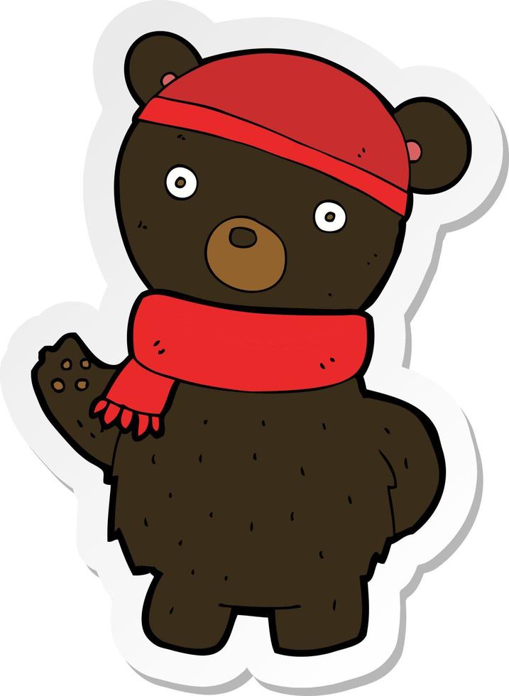 pegatina de un oso negro de dibujos animados con sombrero de invierno y bufanda vector
