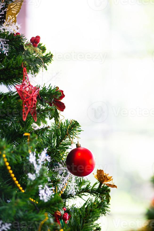 Christmas and New Year holiday concept. Closeup and blur Christmas tree decoration with ribbons balls and ornaments over white brick wall and bokeh photo