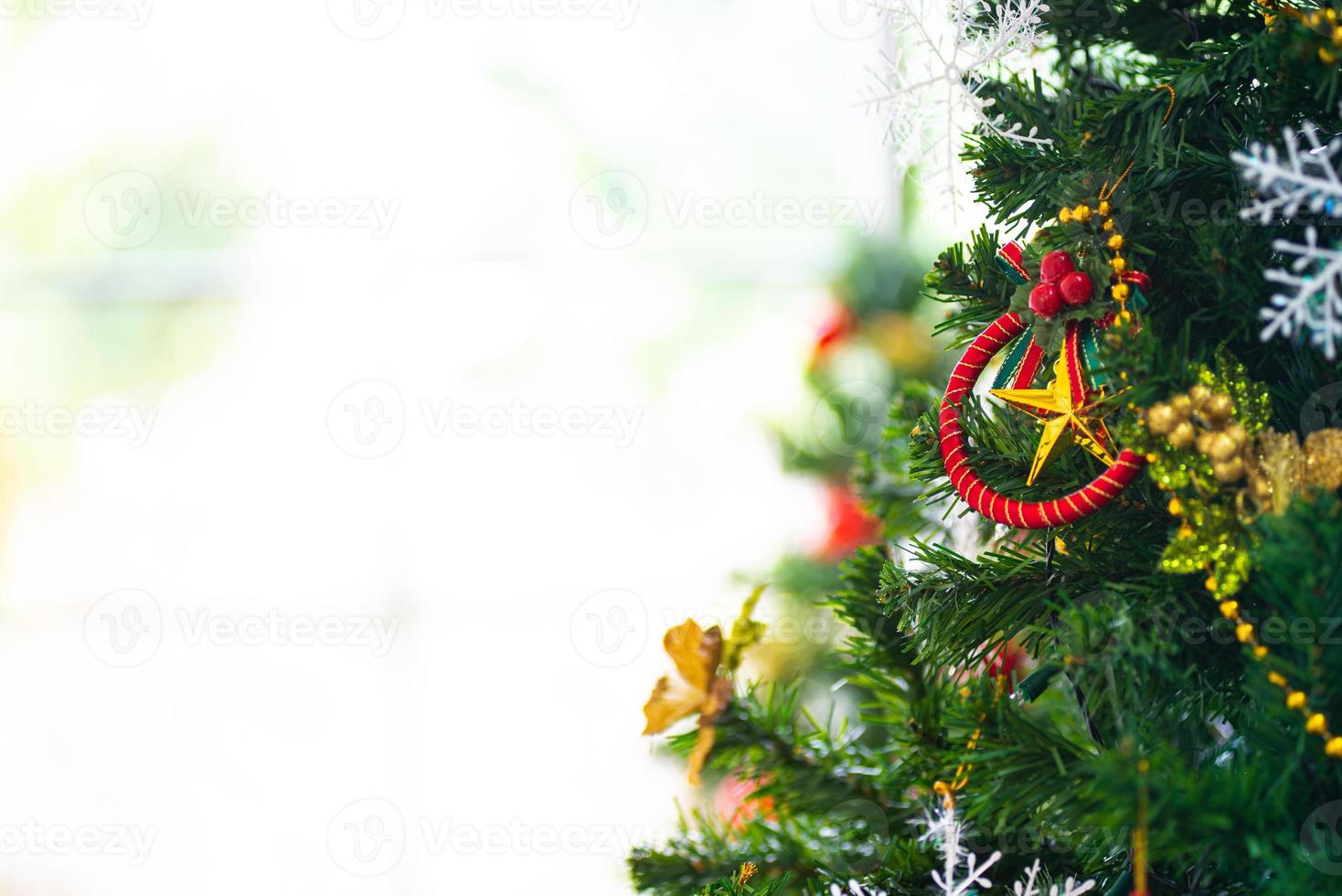 Christmas and New Year holiday concept. Closeup and blur Christmas tree decoration with ribbons balls and ornaments over white brick wall and bokeh photo