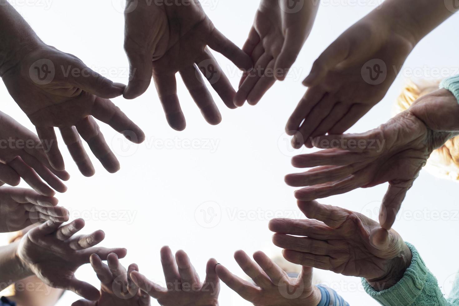 las manos de las personas se doblan al sol y giran para el desarrollo del equipo y la formación de equipos contra el cielo. el concepto de unidad, apoyo mutuo y asistencia mutua. foto