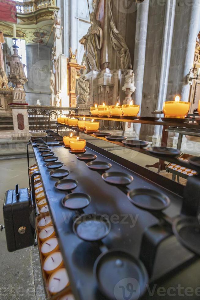 Candles in the Church. Votive prayer candles inside a catholic church on a candle rack. photo