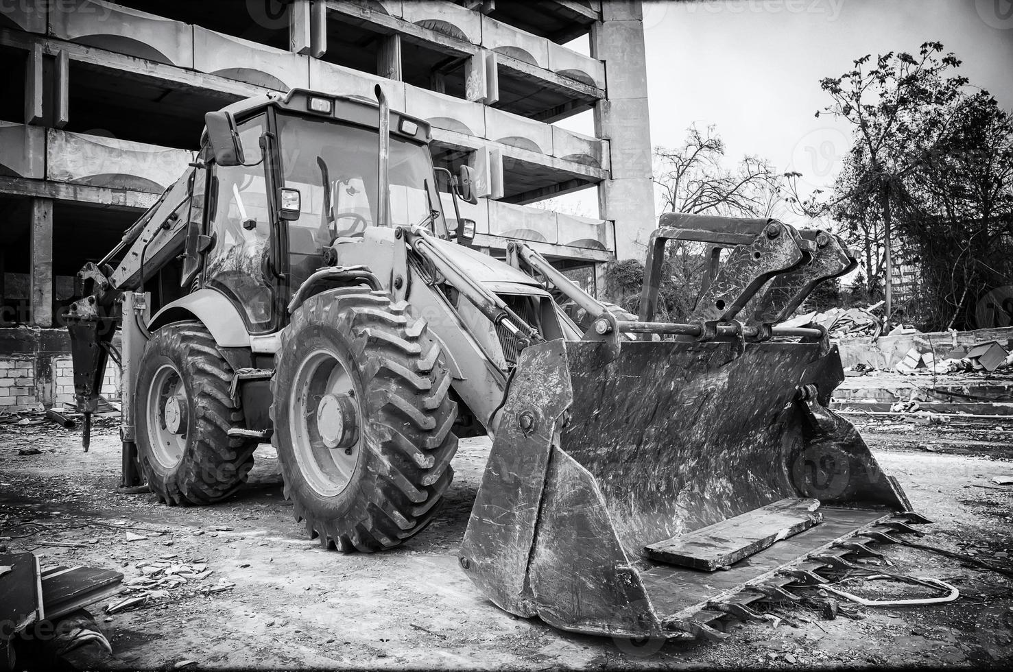 vista vintage en blanco y negro de la excavadora con pala después del trabajo en el sitio de construcción foto