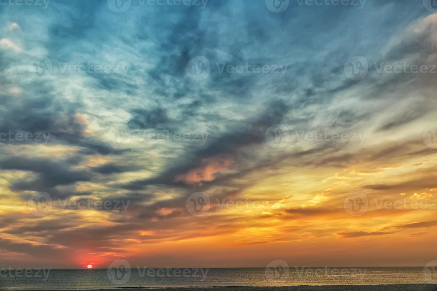 hermosa puesta de sol o amanecer en el mar con nubes impresionantes foto