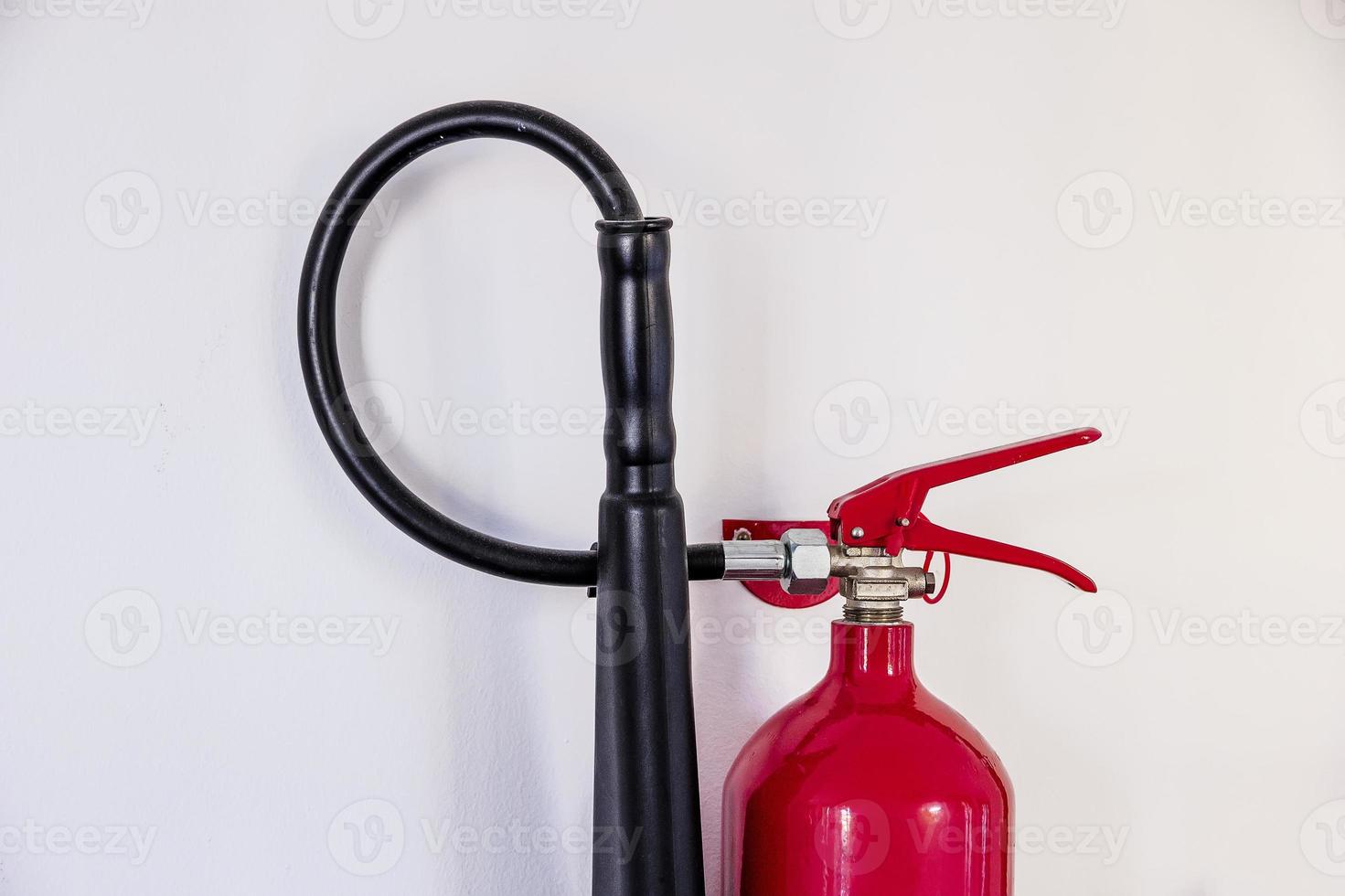 fire extinguisher on the white wall. Horizontal view photo