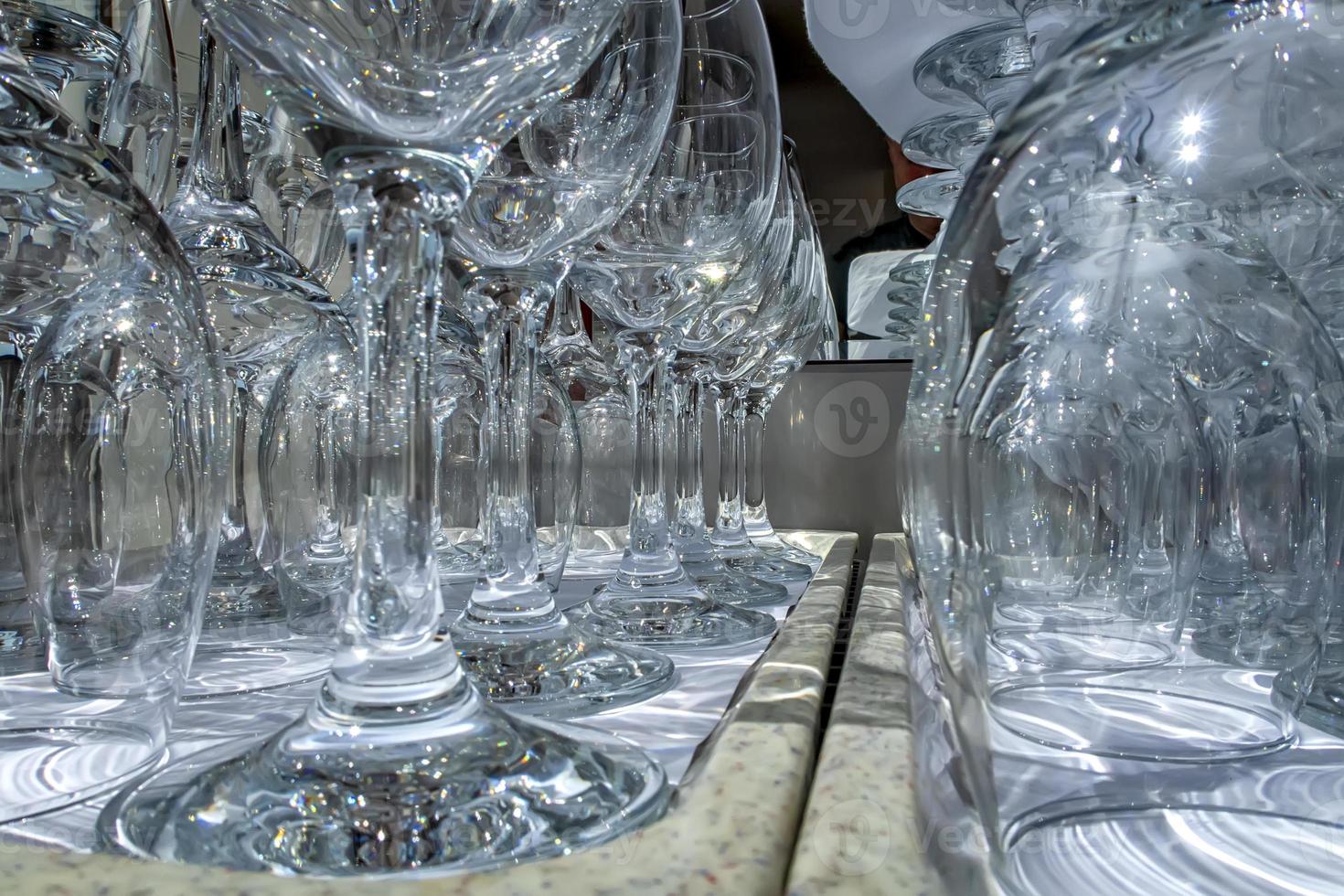 Rows of empty wine glasses close up. Glass goblets on the white table. Restaurant bar concept photo