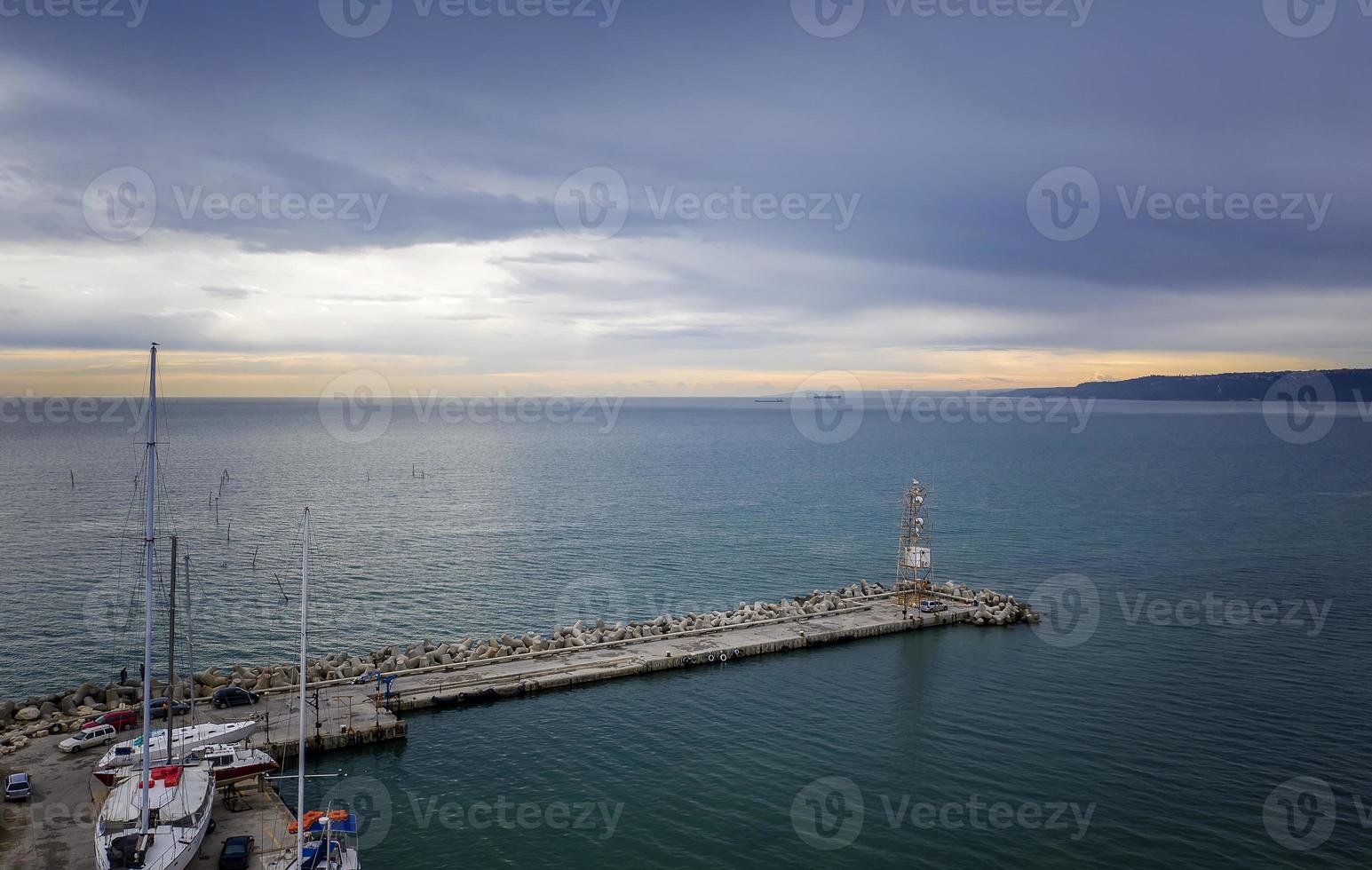 Aerial view from drone of concrete water breaker, and small marina with boats and yachts photo