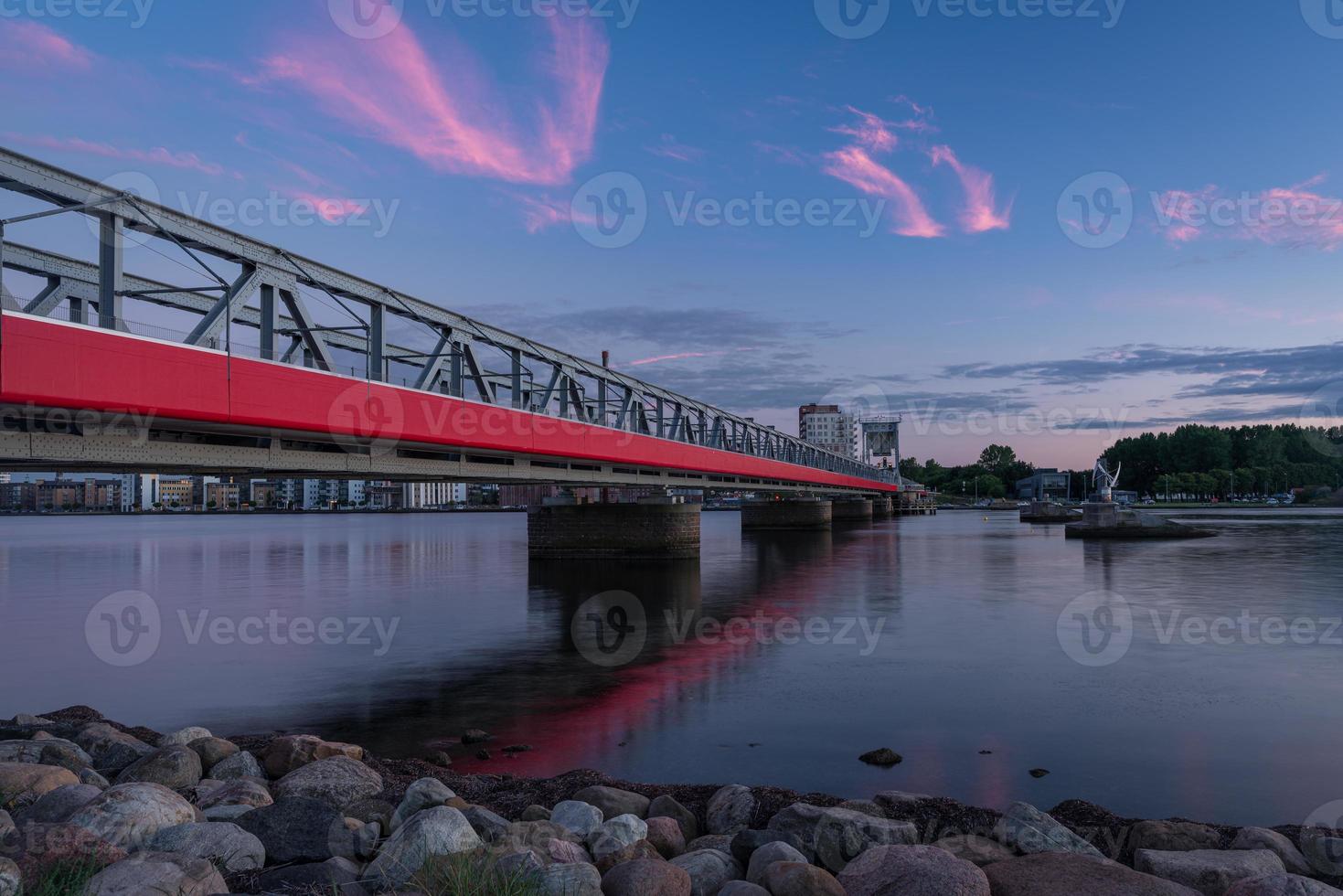 The Cultural Bridge - a train and pedestrian bridge in Aalborg, Denmark, during a colorful sunset photo
