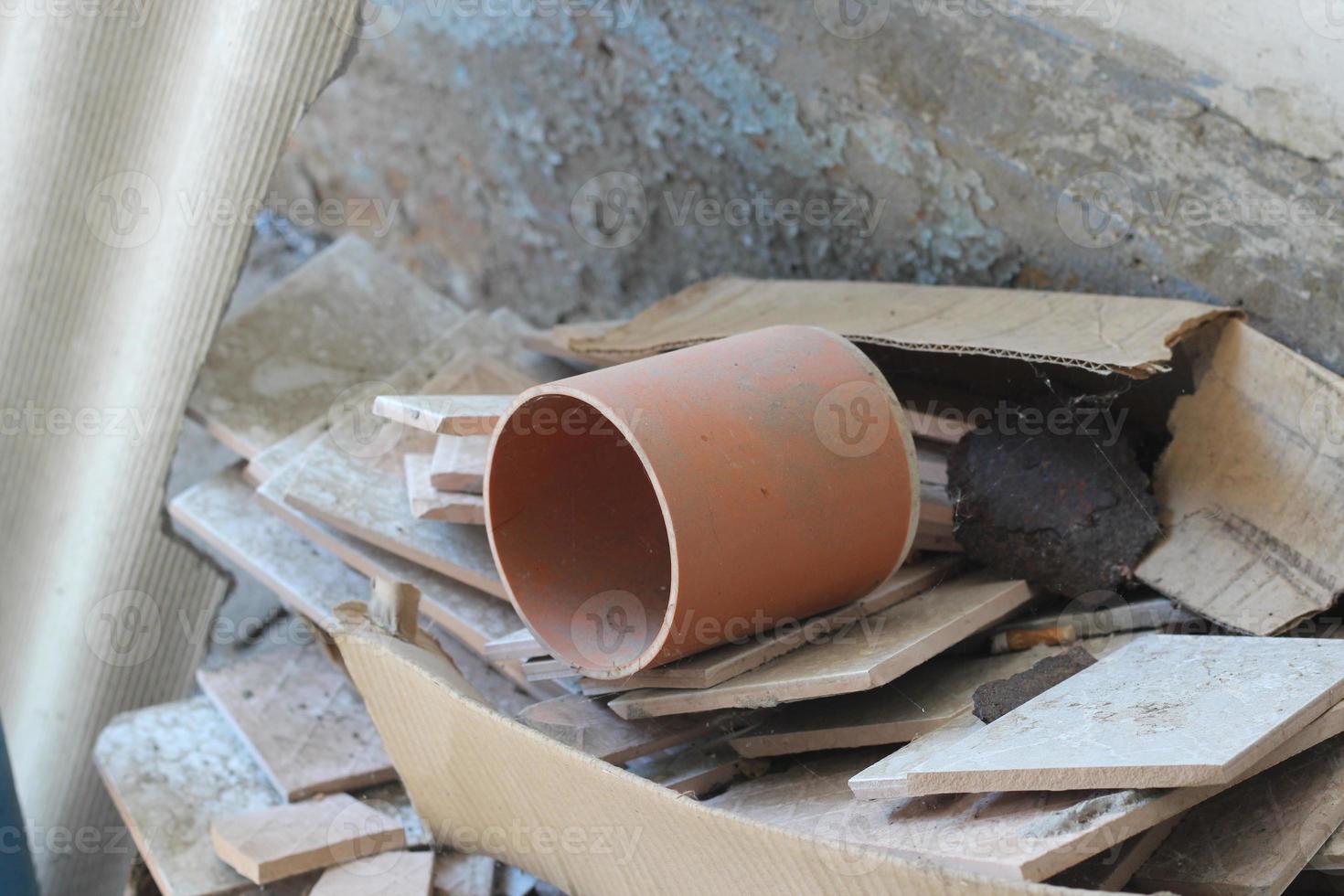 sewer pipe and fragments of ceramic tiles, construction debris after house renovation photo