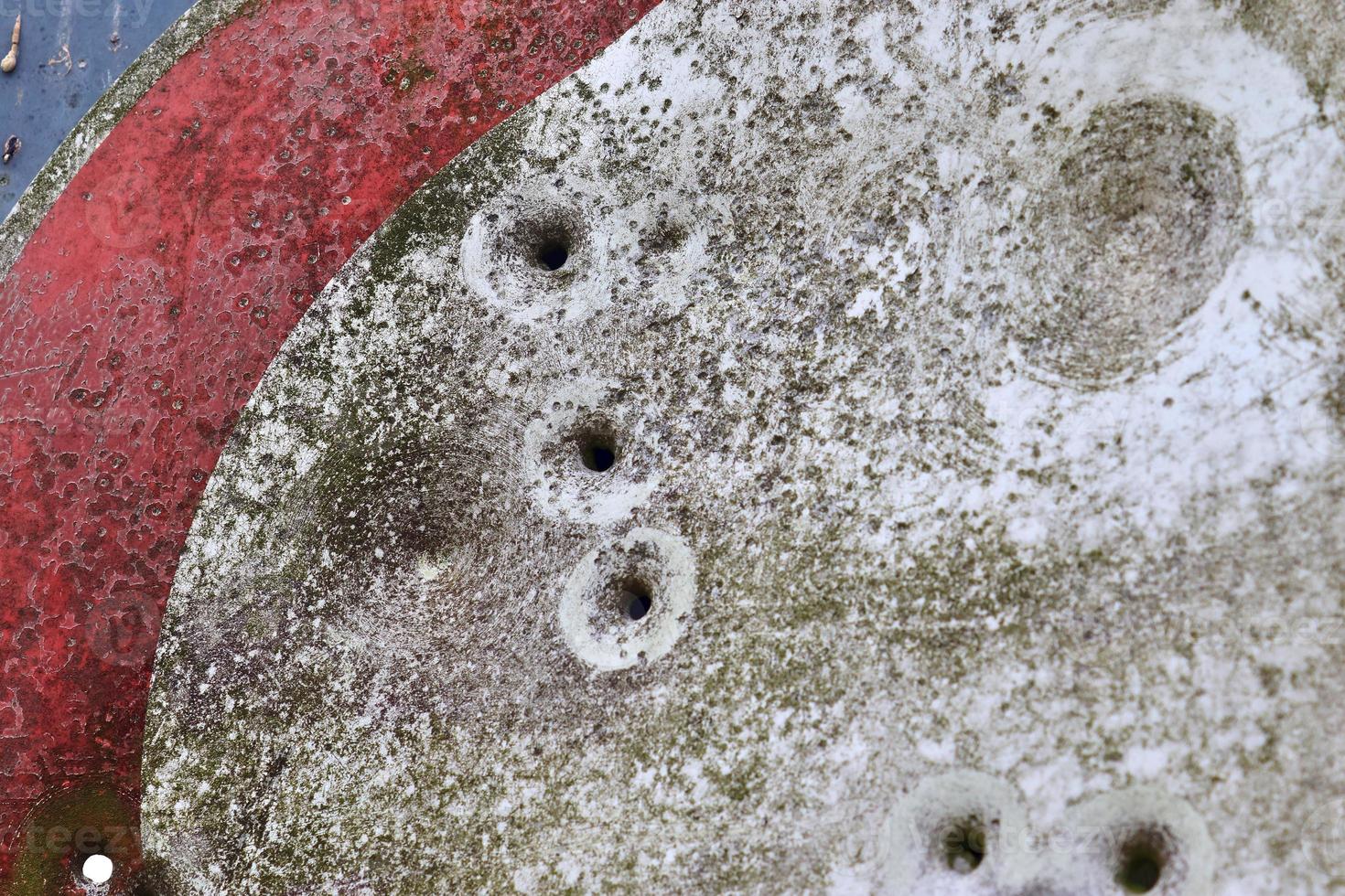 Detailed close up of bullet holes from gun shots in a traffic sign photo