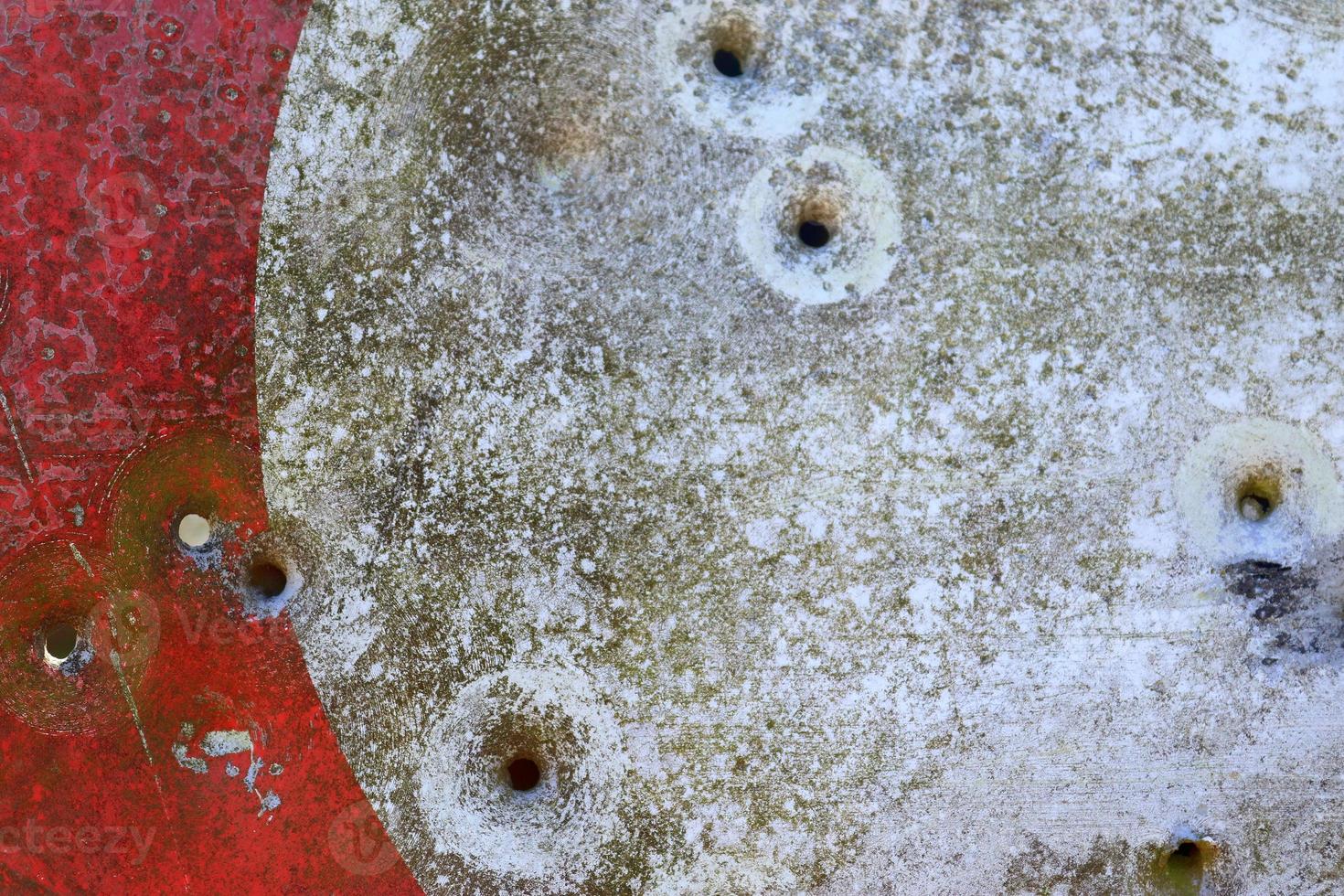 Detailed close up of bullet holes from gun shots in a traffic sign photo