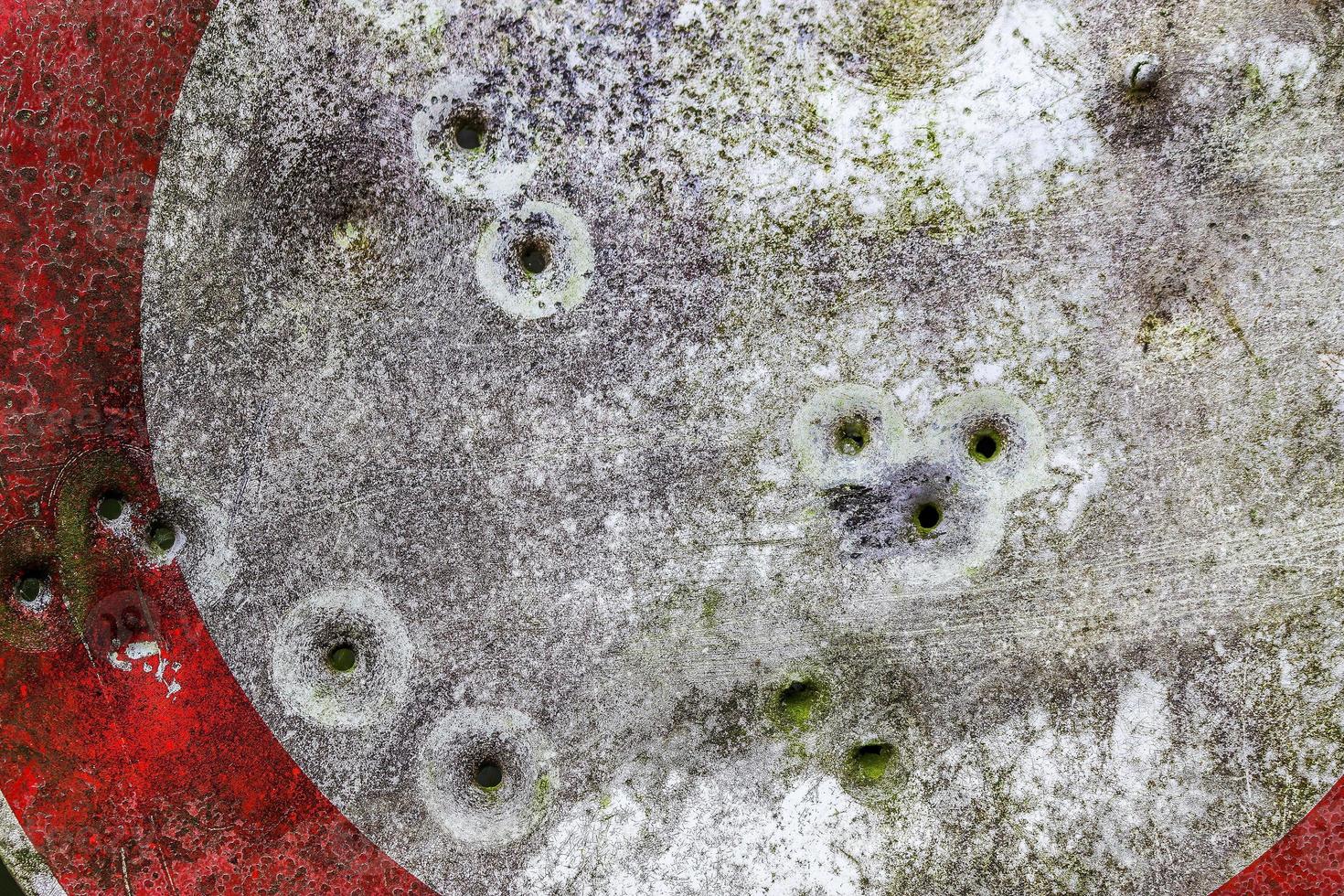 Detailed close up of bullet holes from gun shots in a traffic sign photo