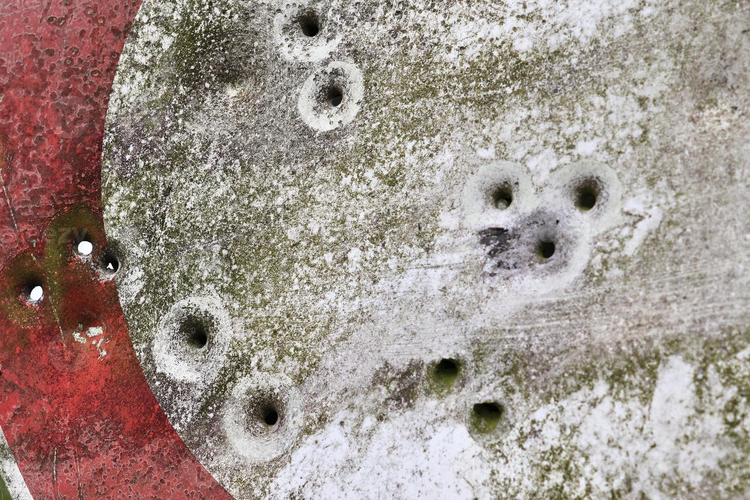Detailed close up of bullet holes from gun shots in a traffic sign photo